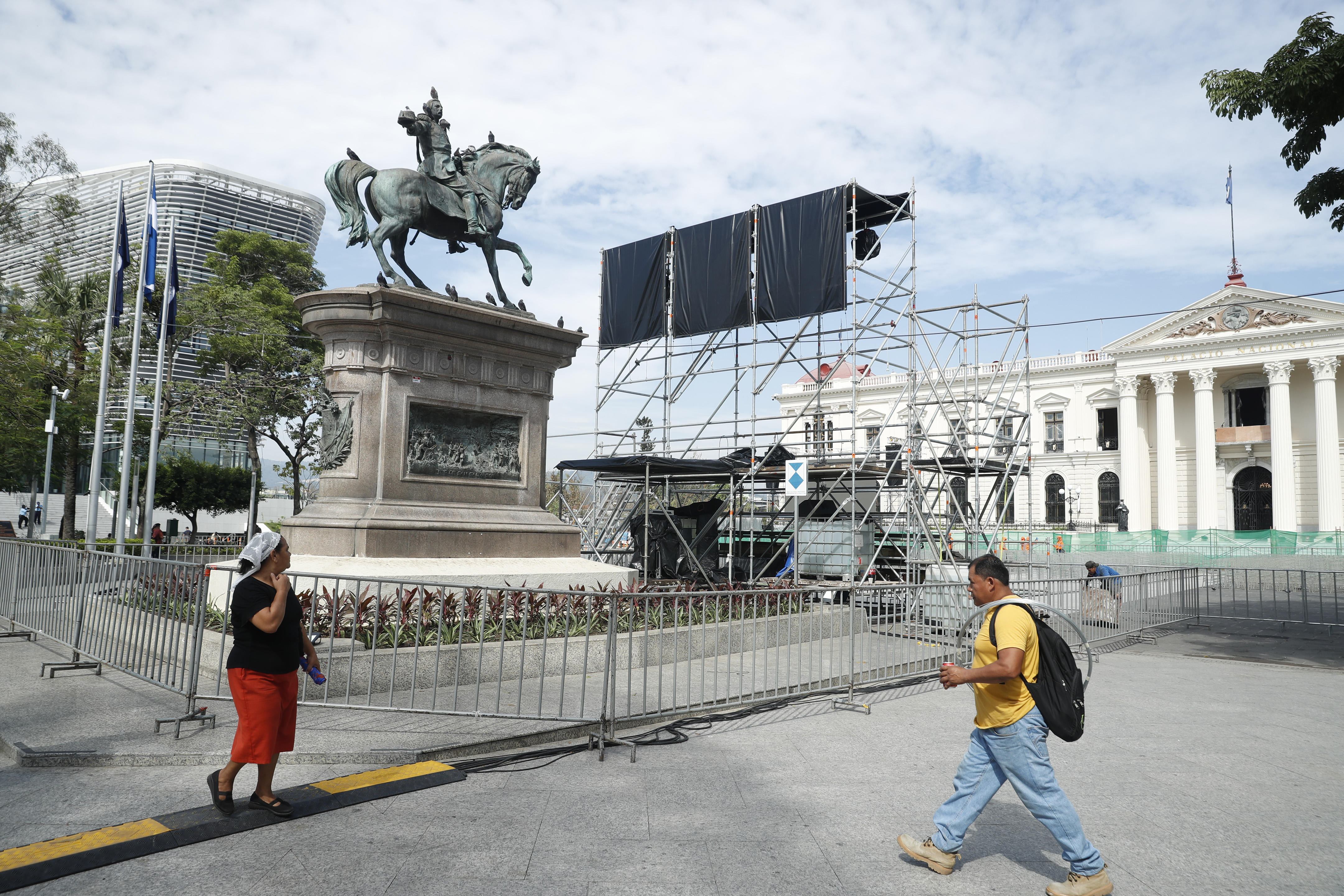ES4001. SAN SALVADOR (EL SALVADOR), 30/05/2024.- Ciudadanos caminan por la plaza Gerardo Barrios mientras se realizan los preparativos para la ceremonia de investidura del segundo mandato de Nayib Bukele, este jueves en San Salvador (El Salvador). Nayib Bukele asumirá un segundo mandato consecutivo el 1 de junio, pese a la prohibición constitucional, con un amplio respaldo popular, con algunas similitudes con gobernantes latinoamericanos del pasado y en momentos en que el Congreso salvadoreño se ha dado así mismo facultades para reformar la Constitución de manera exprés. EFE/ Rodrigo Sura