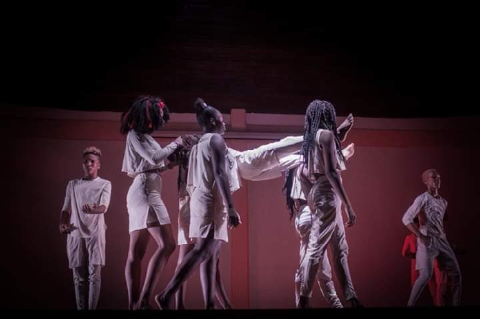 Imagen de una obra de teatro en la que varios jóvenes, hombres y mujeres afrocolombianos, cargan a un actor. Refleja un ritual mortuorio.