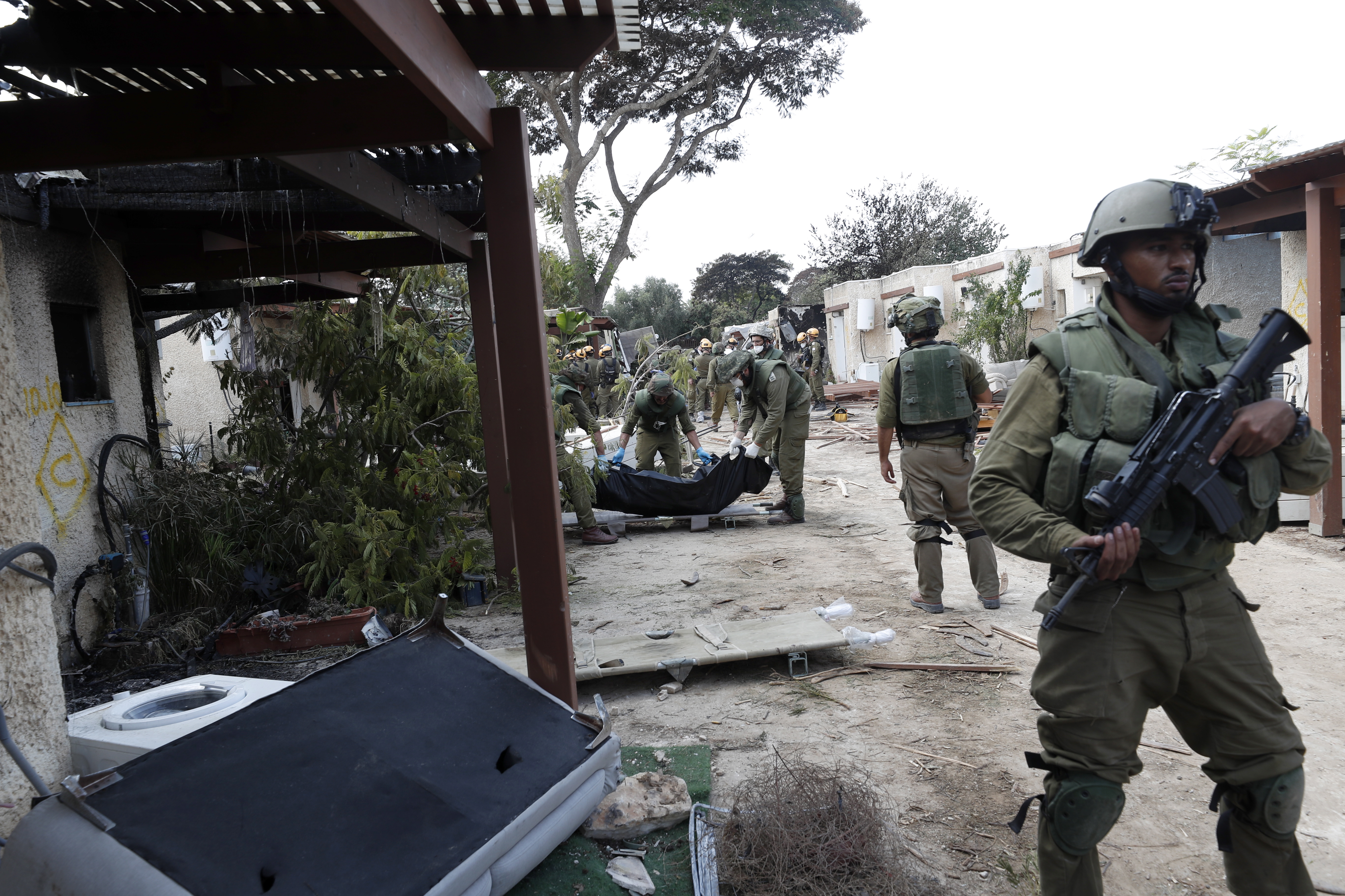 Kfar Aza (Israel), 10/10/2023.- Israeli soldiers take the bodies of Israelis killed in Kfar Aza kibbutz near the border with Gaza, 10 October 2023. More than 900 people have been killed, around 150 were taken as hostages, and 1,500 others injured, according to Israel Defence Forces (IDF), after the Islamist movement Hamas launched an attack against Israel on 07 October. More than 3,000 people, including 1,500 militants from Hamas, have been killed and thousands injured in Gaza and Israel since 07 October, according to Israeli military sources and Palestinian officials. EFE/EPA/ATEF SAFADI