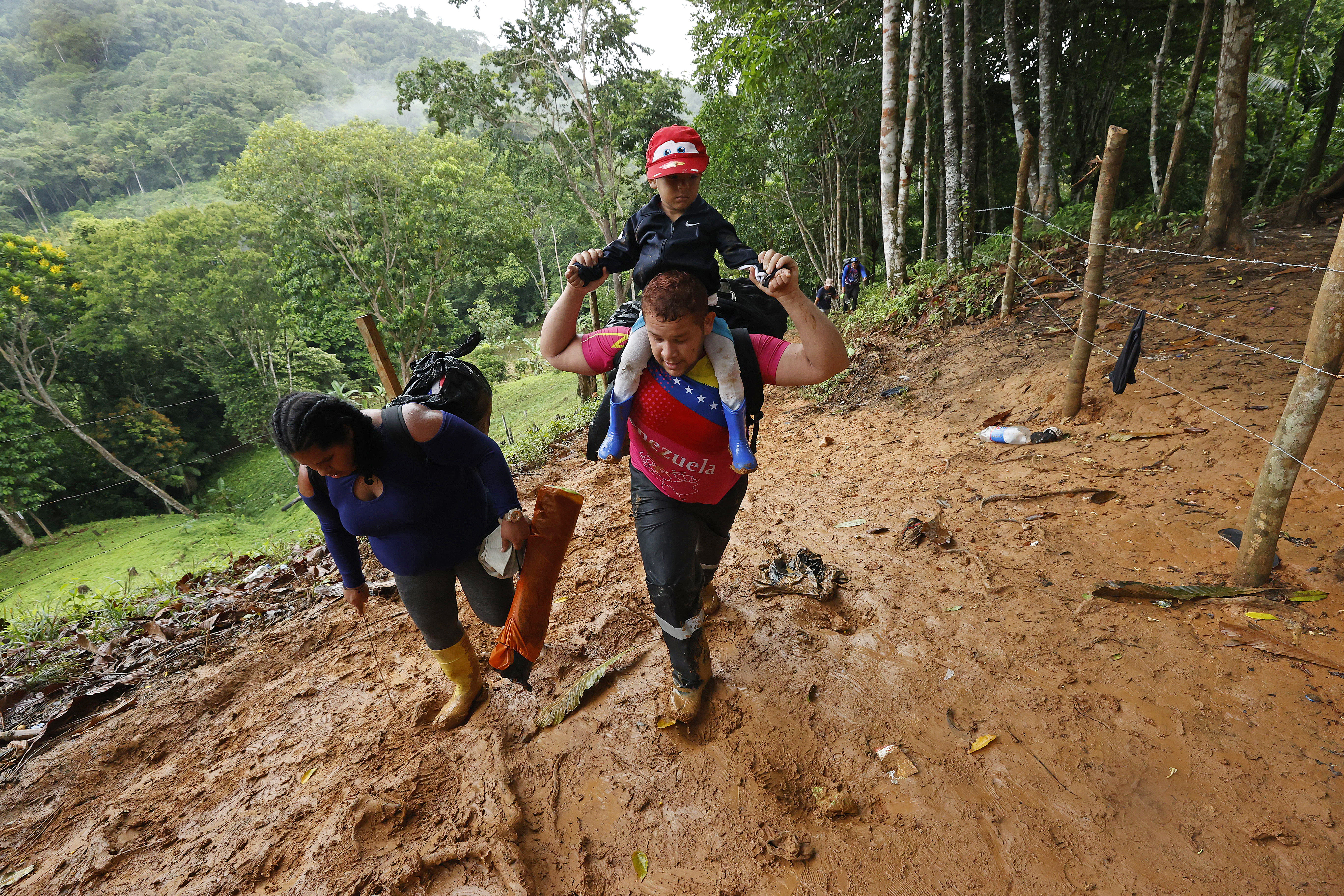 ACOMPAÑA CRÓNICA: CRISIS MIGRATORIA***AME3342. TAPÓN DEL DARIÉN (COLOMBIA), 10/10/2022.- Migrantes venezolanos suben una montaña con la intención de llegar a Panamá, el 8 de octubre de 2022 en el Tapón del Darién (Colombia). Cuando José Juan le dijo a Steven que quería ir a EE.UU. por el Darién, su hijo de 7 años le dijo que eso era peligroso, que era mejor hacerlo en avión, pero aún así ahora lidera enérgico el grupo de migrantes que comienza su travesía por esta inhóspita selva que separa a Colombia de Panamá. Como ellos, más de 150.000 personas -el 60 % de ellos venezolanos- han decidido cruzar en lo que va de año por uno de los pasos migratorios más peligrosos del mundo, una travesía que puede durar la semana por una selva montañosa donde no hay ley. EFE/Mauricio Dueñas Castañeda