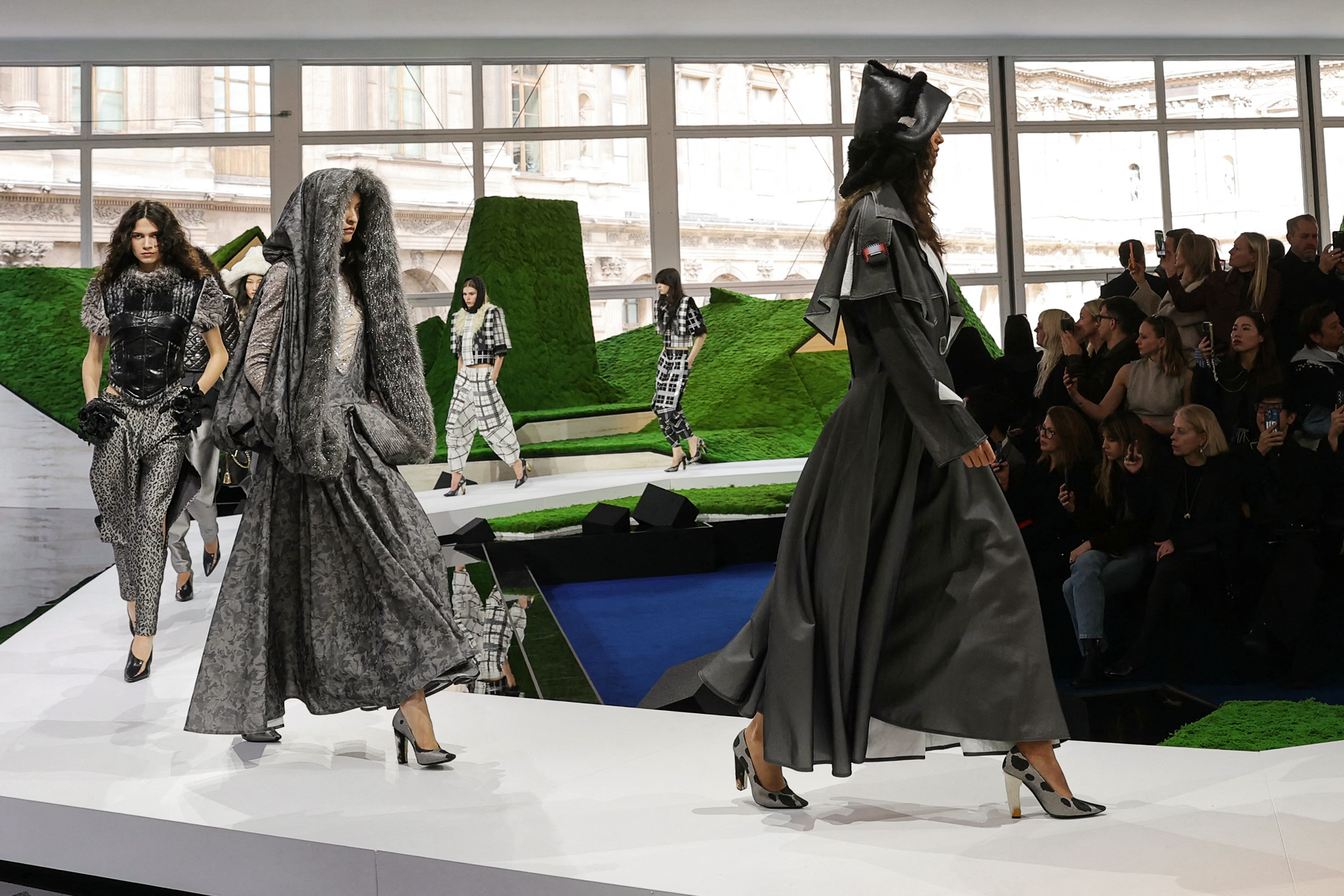 Las modelos desfilan con siluetas de gran volumen frente al paisaje montañoso creado para el show de Louis Vuitton en el último día de la Semana de la Moda femenina de París.