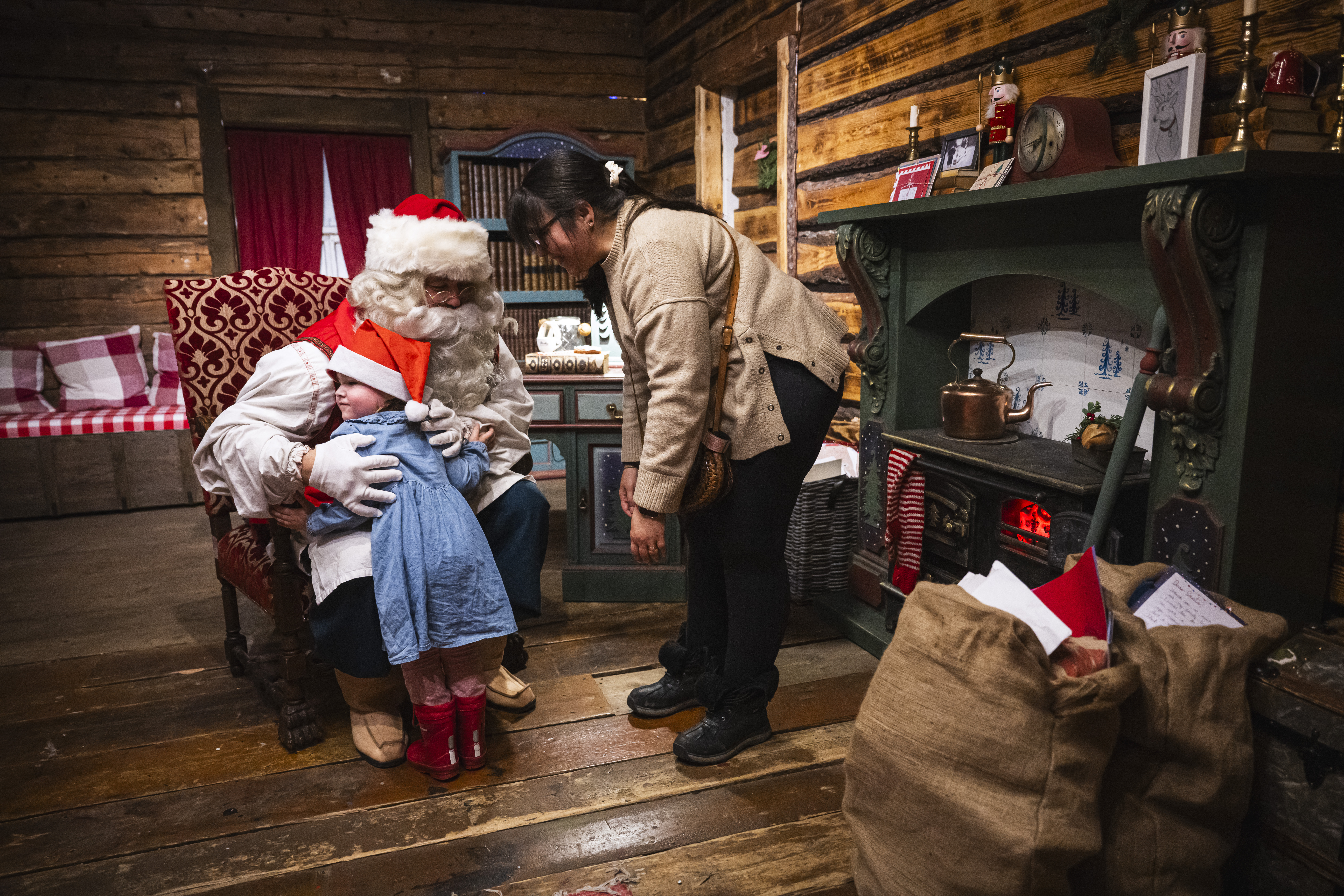A girl and her mom are welcomed by Santa Claus at his office in the Santa Park near Rovaniemi, Finnish Lapland, on November 16, 2024.