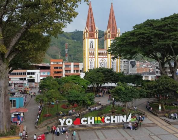 Chinchiná, ubicado a pocos minutos de Manizales y Pereira, es uno de los municipios que mejor representa el corazón del Paisaje Cultural Cafetero. Ha sido históricamente un punto clave para la producción, investigación y abastecimiento del café, una tradición que se consolidó con la creación de Cenicafé en 1938 y se fortaleció en 1973 con una de las fábricas de café liofilizado más modernas del mundo.

Rodeado por miles de hectáreas de café, el municipio también conserva hitos como la Antigua Estación del Ferrocarril, declarada Bien de Interés Cultural, que reflejan su historia y arraigo. A esto se suman logros recientes como el Guinness World Record obtenido en 2019 por la taza de café más grande del mundo, con capacidad para 22.000 litros.
