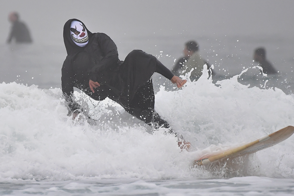 Surfistas disfrazados festejan Halloween entre las olas