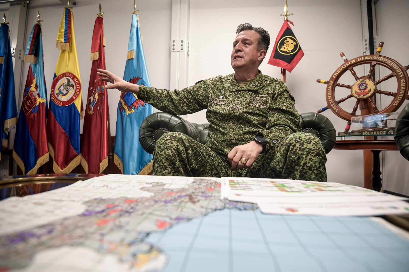 El almirante Francisco Cubides habla durante entrevista con El Espectador. En frente suyo, un mapa del suroccidente nacional con la ubicación exacta de los grupos armados organizados.