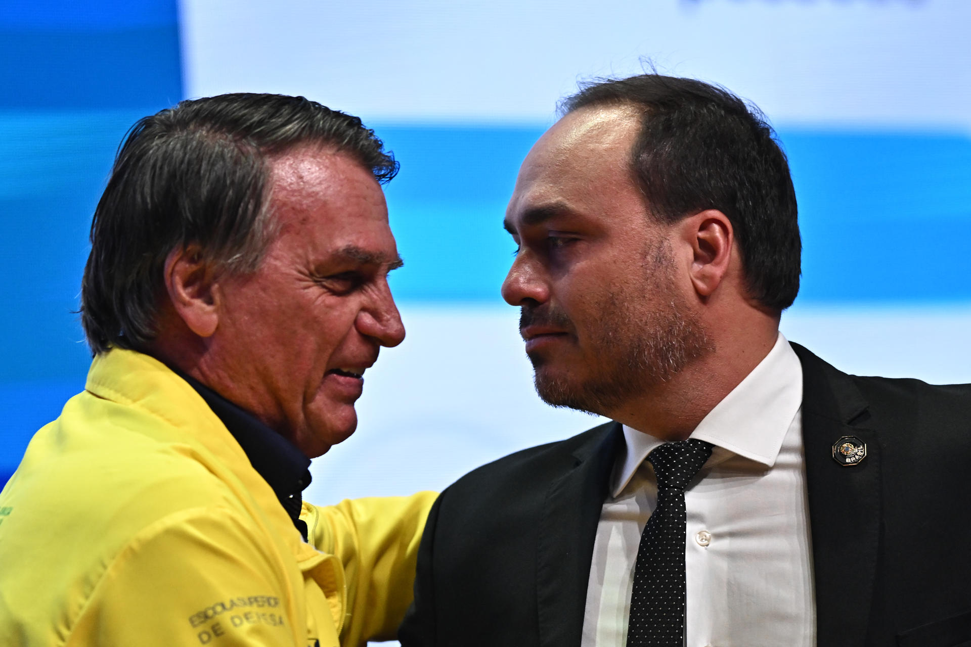 AME2444. BOGOTÁ (COLOMBIA), 27/08/2026.- Fotografía de archivo del 21 de febrero de 2025 del expresidente de Brasil Jair Bolsonaro (i) junto a su hijo Carlos Bolsonaro, durante un evento del Partido Liberal en Brasilia (Brasil). El expresidente brasileño Jair Bolsonaro, inhabilitado y condenado por golpismo, no podrá disputar las elecciones, pero su esposa, sus hijos, su hermano y hasta su exmujer están decididos a prolongar su legado en la Cámara de Diputados, el Senado y, de nuevo, en la Presidencia. EFE/ Andre Borges ARCHIVO
