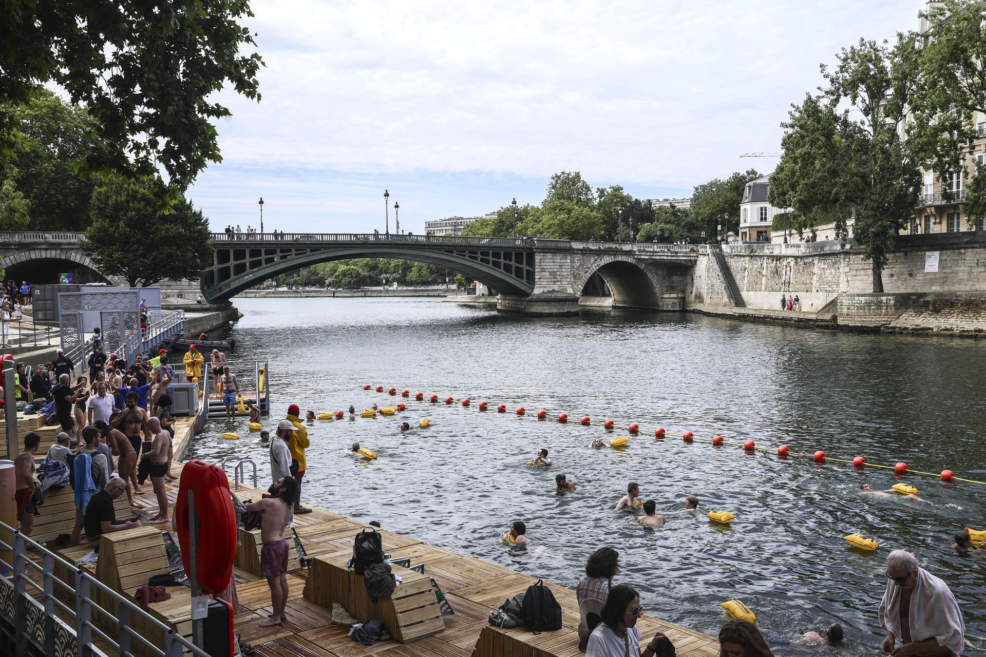 Paris (France), 05/07/2025.- People swim near the Pont Marie, one of the three safe swimming areas that opened to the public on the Seine River, in Paris, France, 05 July 2025. From 05 July to 31 August 2025, people will be able to swim in three safe swimming areas on the Seine river, an activity that has been banned since 1923. (Francia) EFE/EPA/TERESA SUAREZ