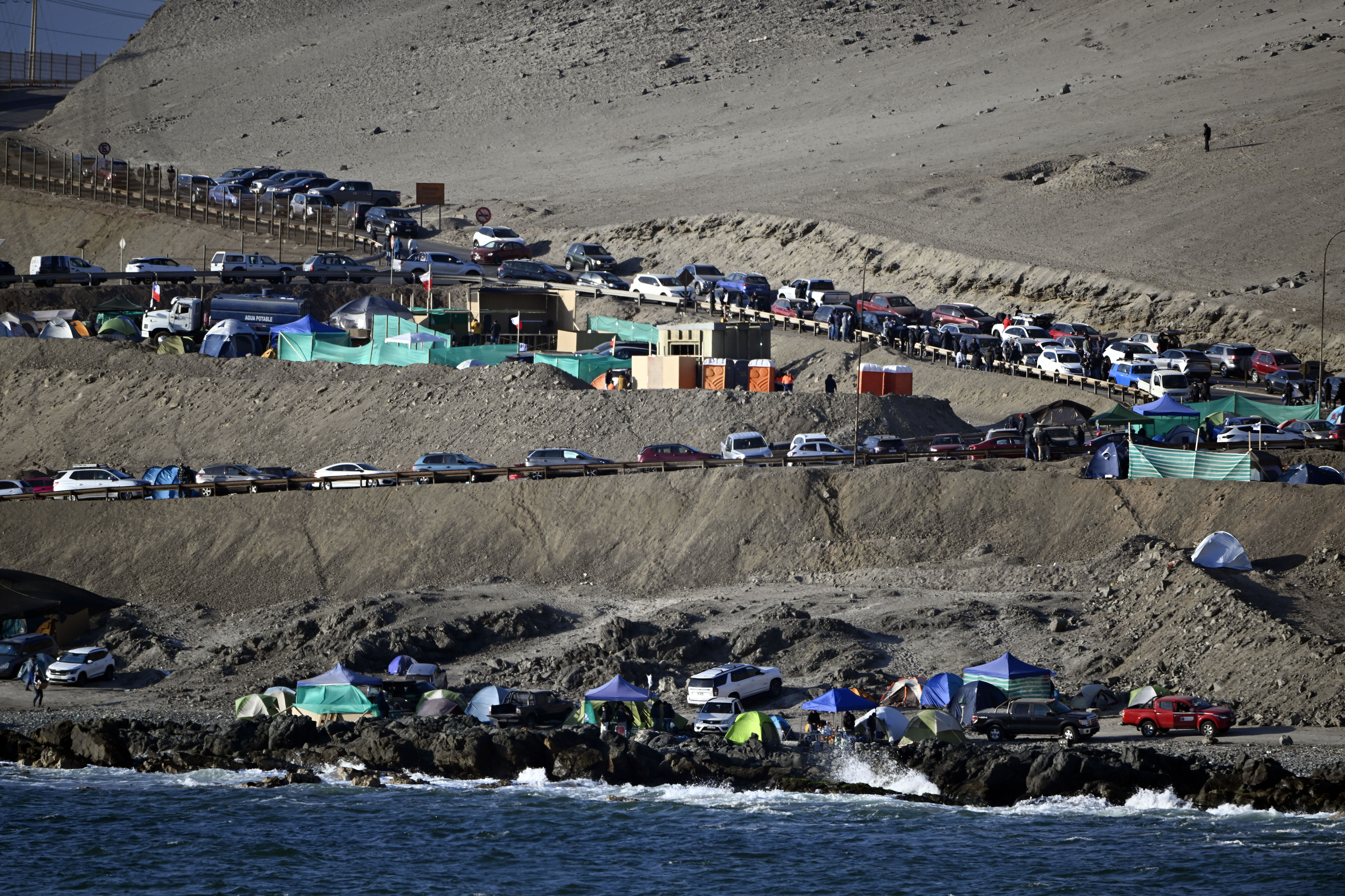 -FOTODELDÍA- CH0. ANTOFAGASTA (CHILE), 15/08/2024.- Trabajadores de la Minera Escondida acampan en las afueras del Puerto Coloso, donde se ubican las instalaciones portuarias de la minera, este jueves en la región de Antofagasta (Chile). La huelga del Sindicato N°1 de Minera Escondida, la mina de cobre a cielo abierto en Chile que más produce en el mundo, cursa este jueves su tercer día y arriesga pérdidas diarias por 30 millones de dólares (27,3 millones de euros) según la empresa. EFE/ Pedro Tapia