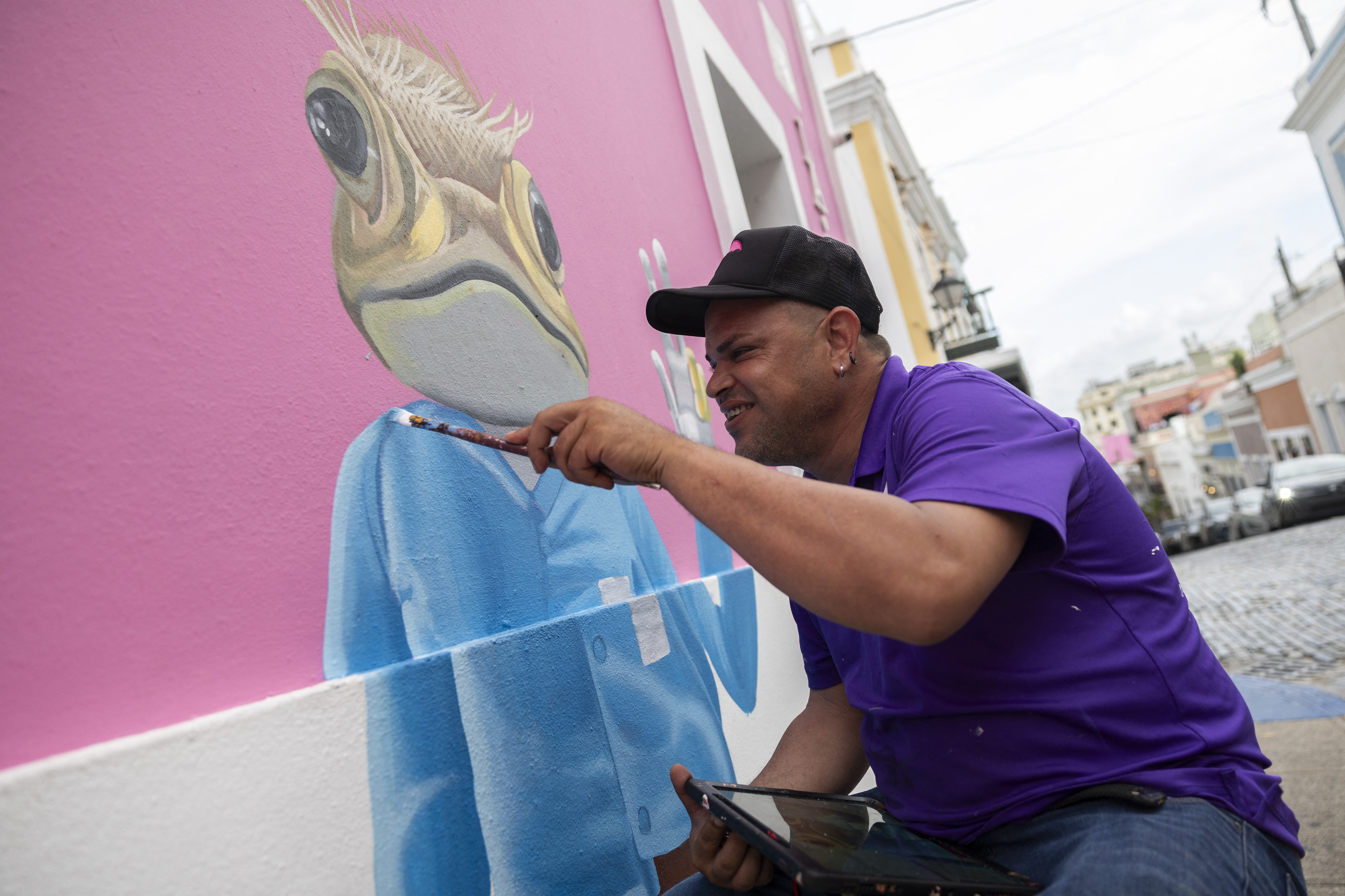 Puerto Rican artist Humberto Olivieri paints a sapo concho (Puerto Rican toad) mural in Old San Juan, Puerto Rico on May 13, 2025.
