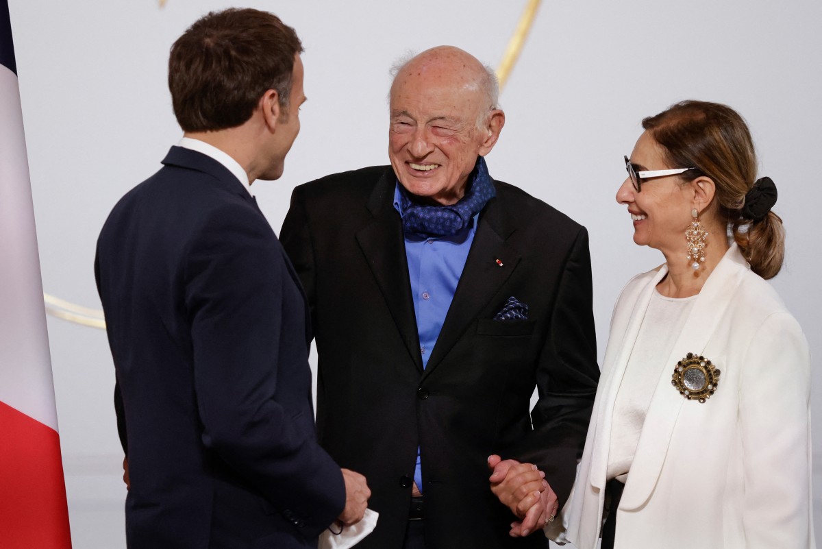 (FILES) French President Emmanuel Macron (L) greets French philosopher and sociologist Edgar Morin (C) and his wife Sabah Abouessalam (R) during a ceremony to mark his 100th birthday at the Elysee Palace in Paris, on July 8, 2021.