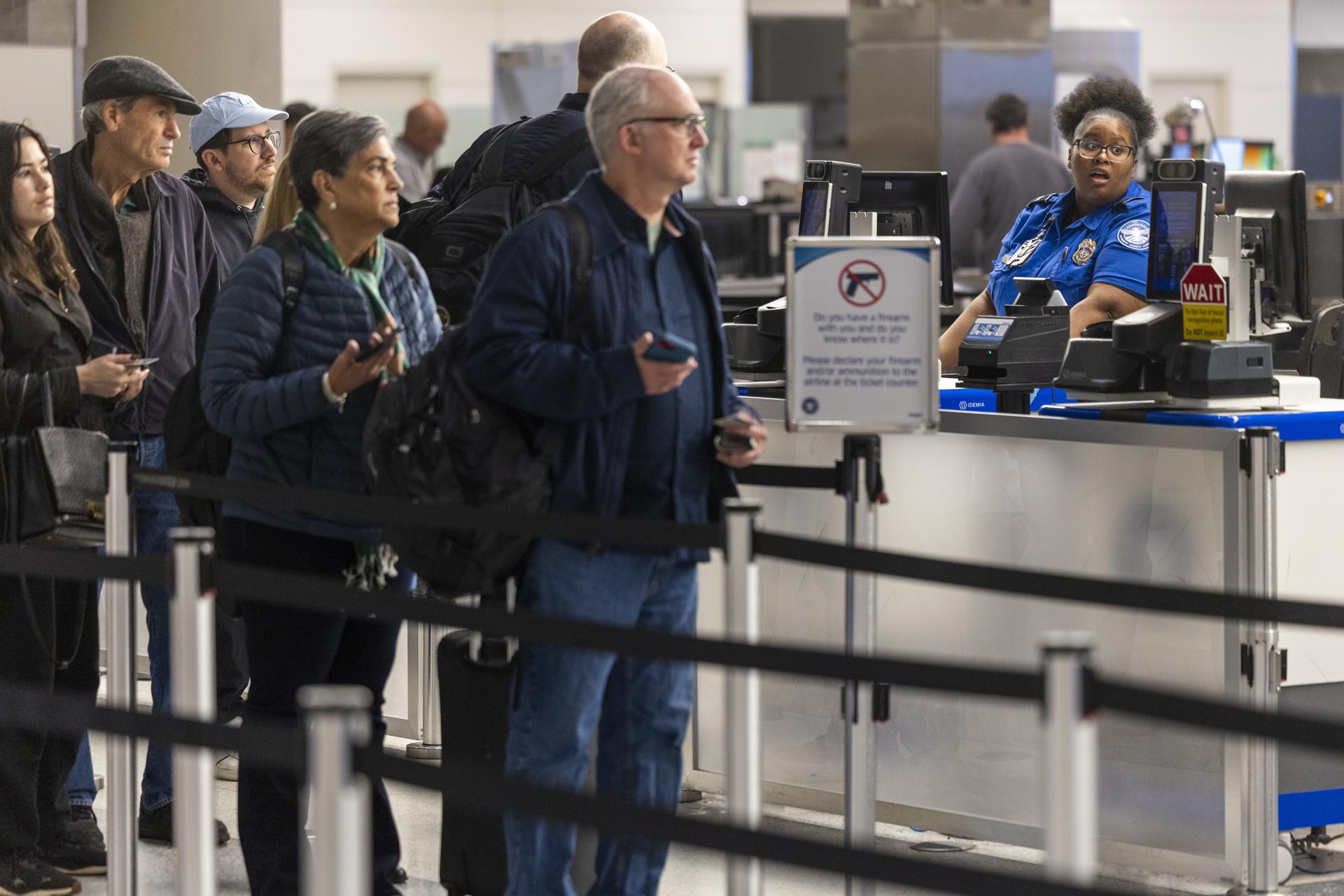ARLINGTON (United States), 17/03/2026.- Transportation Security Administration (TSA) security officers screen passengers at the North Security Checkpoint at Washington Reagan National Airport in Arlington, Virginia, USA, 17 March 2026. Roughly 50,000 TSA officers are working unpaid due to the partial shutdown at the Department of Homeland Security, with waits exceeding 2–3 hours or more at major airports due to increased TSA absenteeism. EFE/EPA/SHAWN THEW