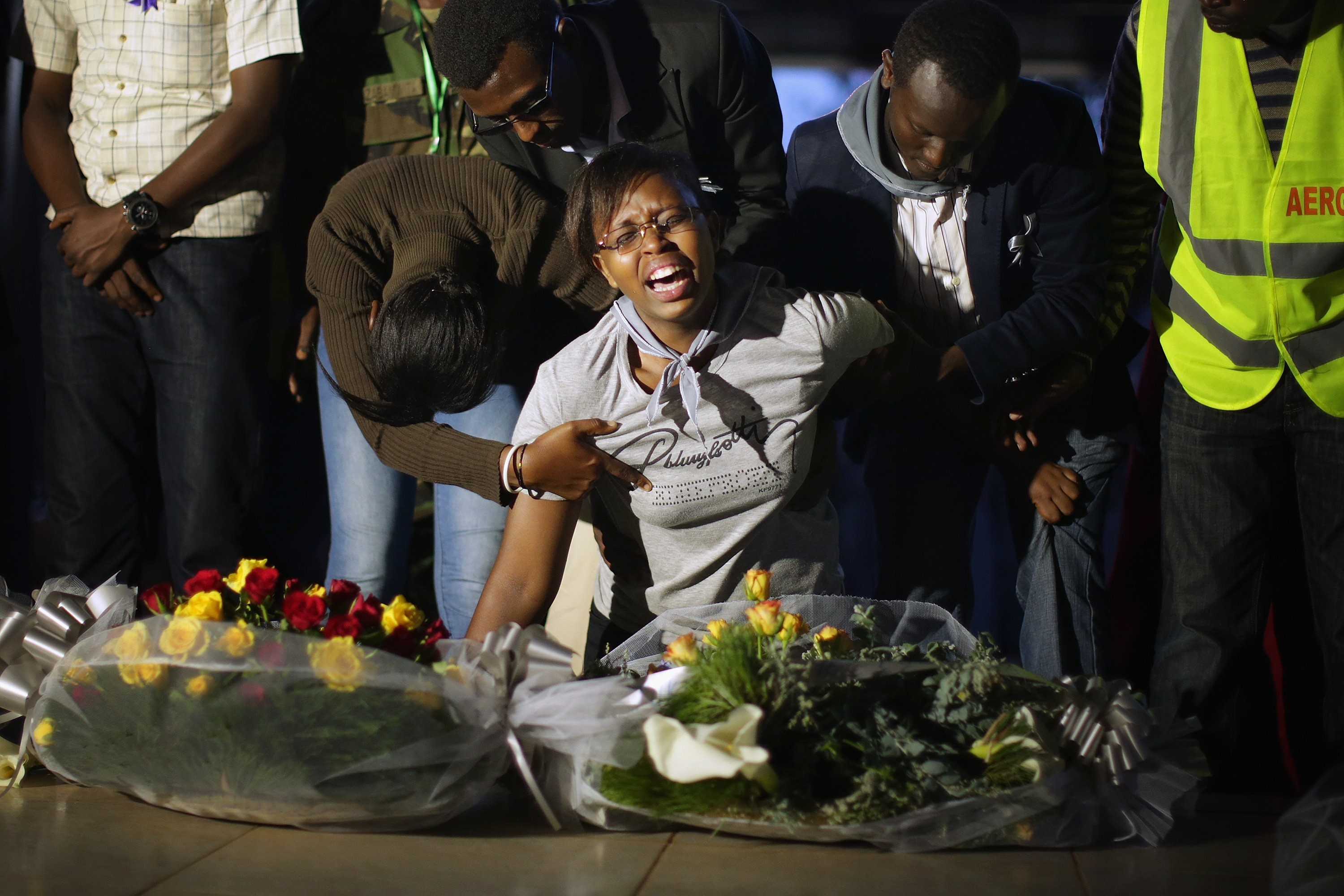 Abrumada por el dolor, una mujer grita: '¡Mon pre!' Mientras estaba arrodillado junto a una de las fosas comunes en el monumento conmemorativo del genocidio de Nyanza-Kicukiro, 20 años después de que 2.000 personas fueran asesinadas por el gobierno extremista y la milicia Interahamwe después de ser abandonadas por las tropas de las Naciones Unidas durante el genocidio de 1994, el 11 de abril de 2014 en Kigali, Ruanda. . Los ruandeses ven la marcha forzada y la matanza de tutsis que se refugiaron con las tropas de la UNAMIR de Bélgica en la cercana escuela técnica como un ejemplo de su abandono por parte de la comunidad internacional. Han pasado 20 años desde que un gobierno extremista inició 100 días de terror en los que fueron asesinados más de 800.000 personas de etnia tutsis y hutus moderados.