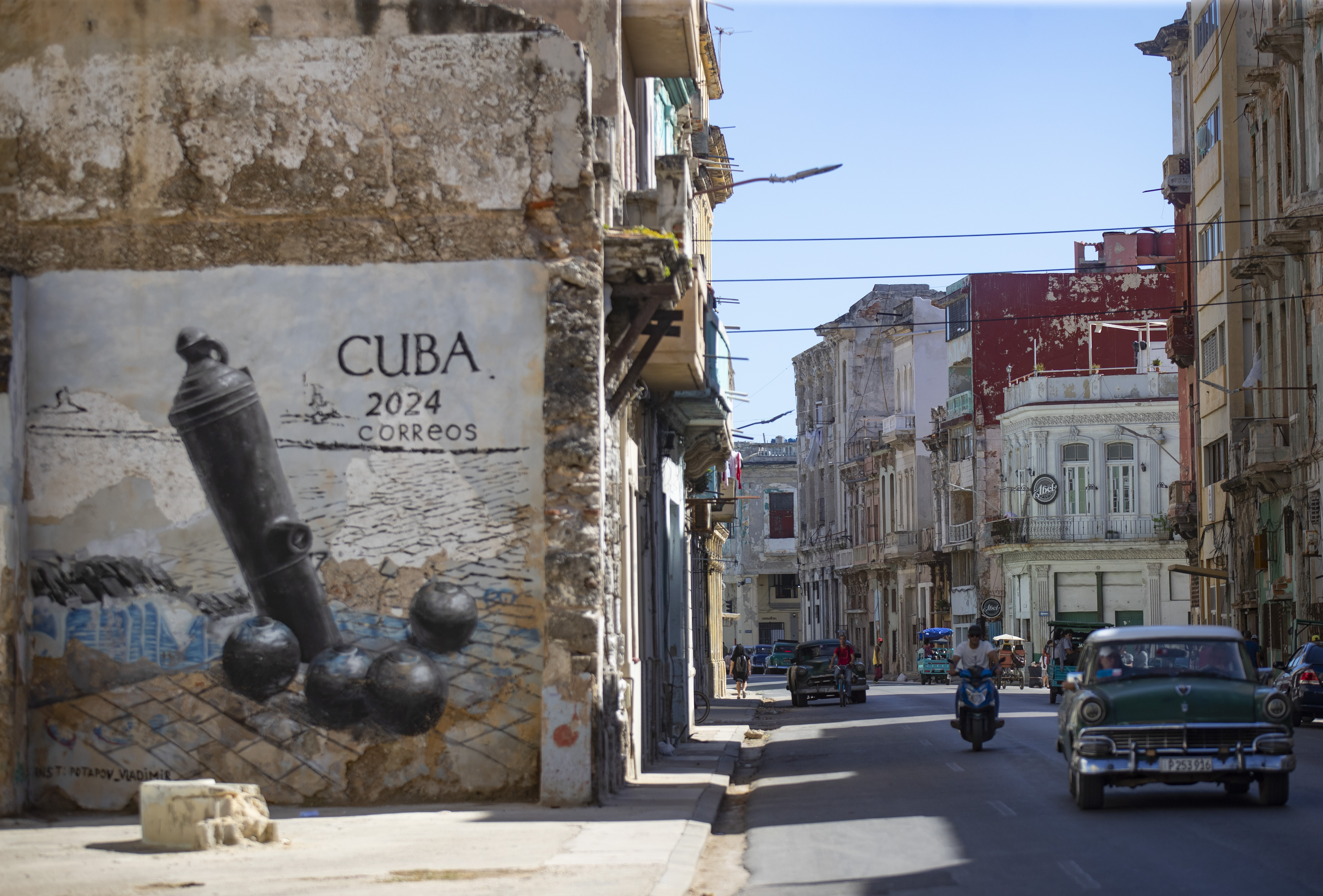 AME8987. LA HABANA (CUBA), 19/11/2024.- Un carro pasa frente a un graffiti en la calle San Lázaro, este martes en La Habana (Cuba). Las calles del centro histórico de la capital de Cuba se han convertido estos días en parte del escenario de la Bienal de La Habana, una de las principales citas culturales del país, donde cerca de 400 artistas, 230 de ellos extranjeros, exponen sus obras en una mirada de exposiciones, actuaciones y performances que arrancaron este noviembre y se prolonga hasta finales de febrero. EFE/Yander Zamora