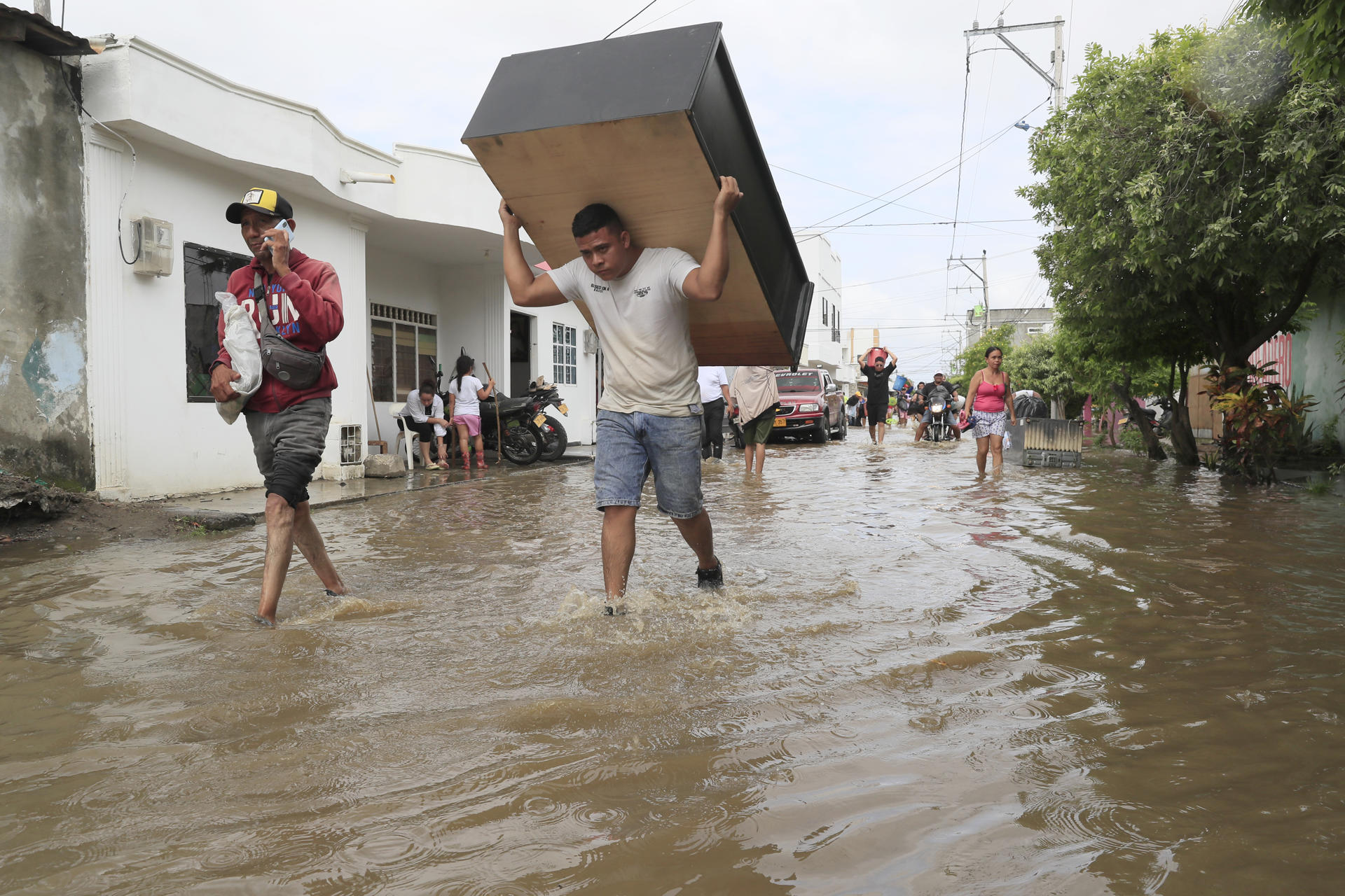 AME2911. MONTERÍA (COLOMBIA), 07/02/2026.- Personas intentan rescatar sus pertenencias este sábado luego de una nueva creciente del río Sinú que afectó el barrio El Dorado en Montería (Colombia). El presidente colombiano Gustavo Petro anunció que decretará un nueva emergencia social, económica y ambiental para hacerle frente a las inundaciones que afectan gran parte de Colombia. EFE/ Carlos Ortega
