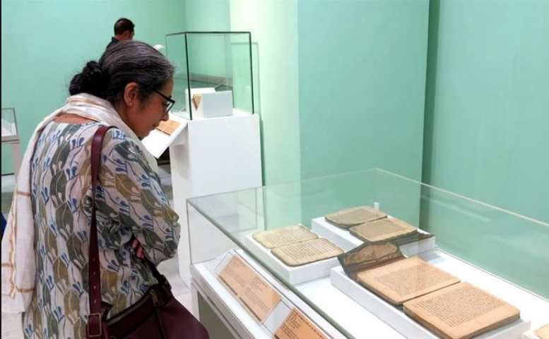 Una mujer contempla algunos de los manuscritos de Tombuctú en el Museo Nacional de Nueva Delhi. / AFP