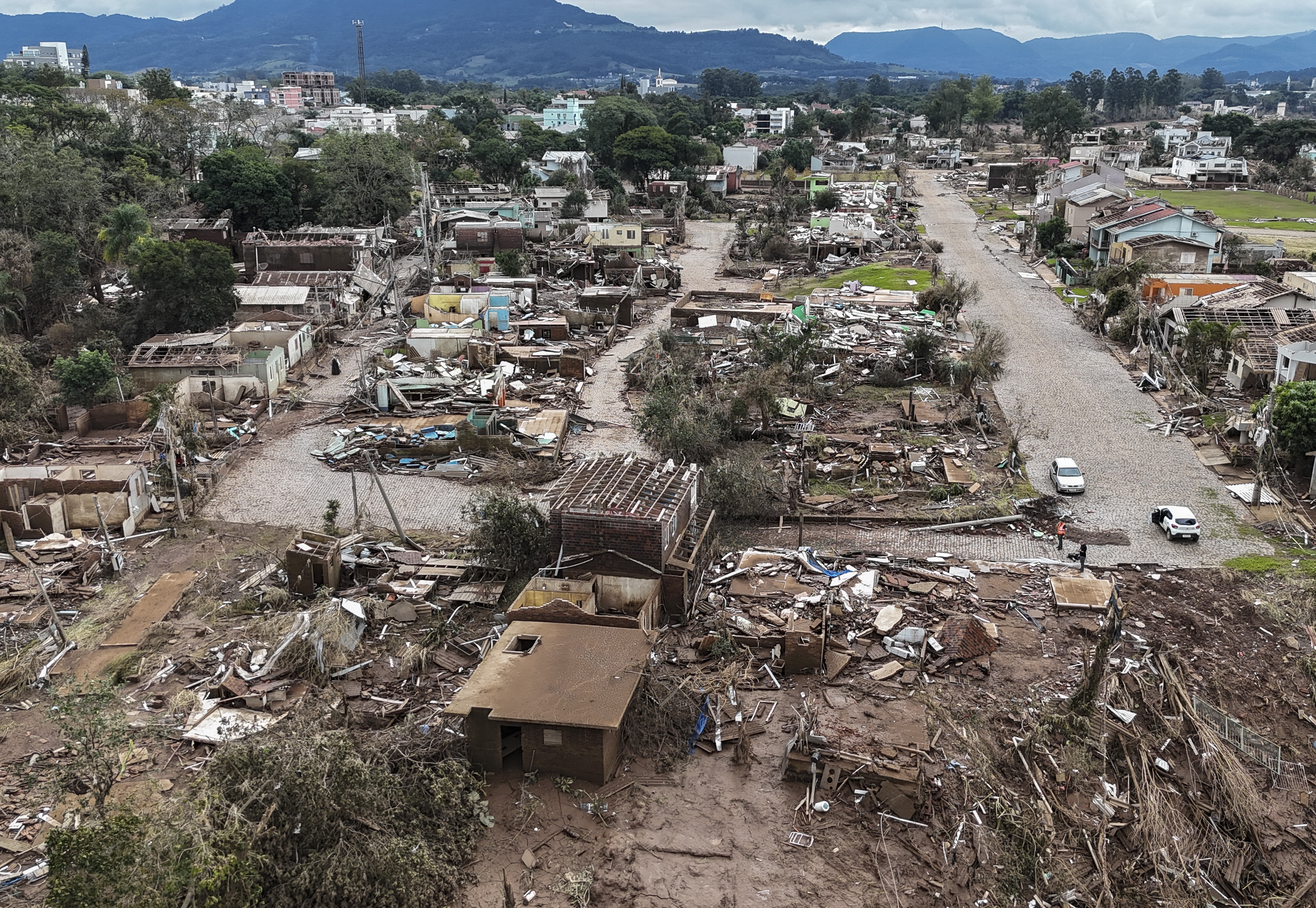 AME4960. LAJEADO (BRASIL), 09/05/2024.- Fotografía aérea que muestra casas destruidas tras la inundación causada por el desbordamiento del río Forqueta, un afluente del río Taquari, este jueves en Lajeado (Brasil). Con buques de guerra, aviones cargueros y hospitales de campaña, las Fuerzas Armadas de Brasil desplegaron un enorme operativo para auxiliar a las víctimas de las devastadoras inundaciones en el sur del país, que han dejado al menos 108 fallecidos, 136 desaparecidos y ciudades enteras bajo el agua. EFE/ Sebastião Moreira