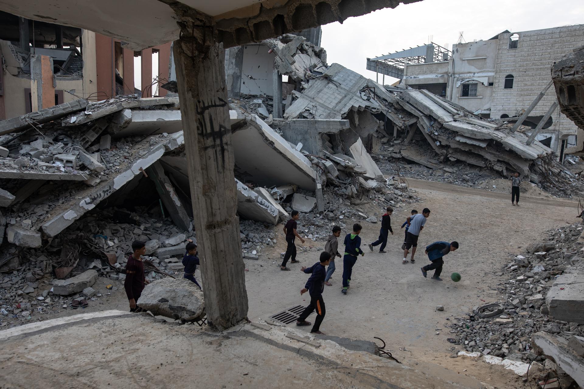 GAZA (-), 24/11/2025.- Palestinian children play football next to their destroyed homes in Khan Younis, southern Gaza Strip, 24 November 2025. Around 1.9 million people in Gaza, nearly 90 percent of the population, have been displaced since the Israel-Hamas conflict began in October 2023, according to the UN. EFE/EPA/HAITHAM IMAD