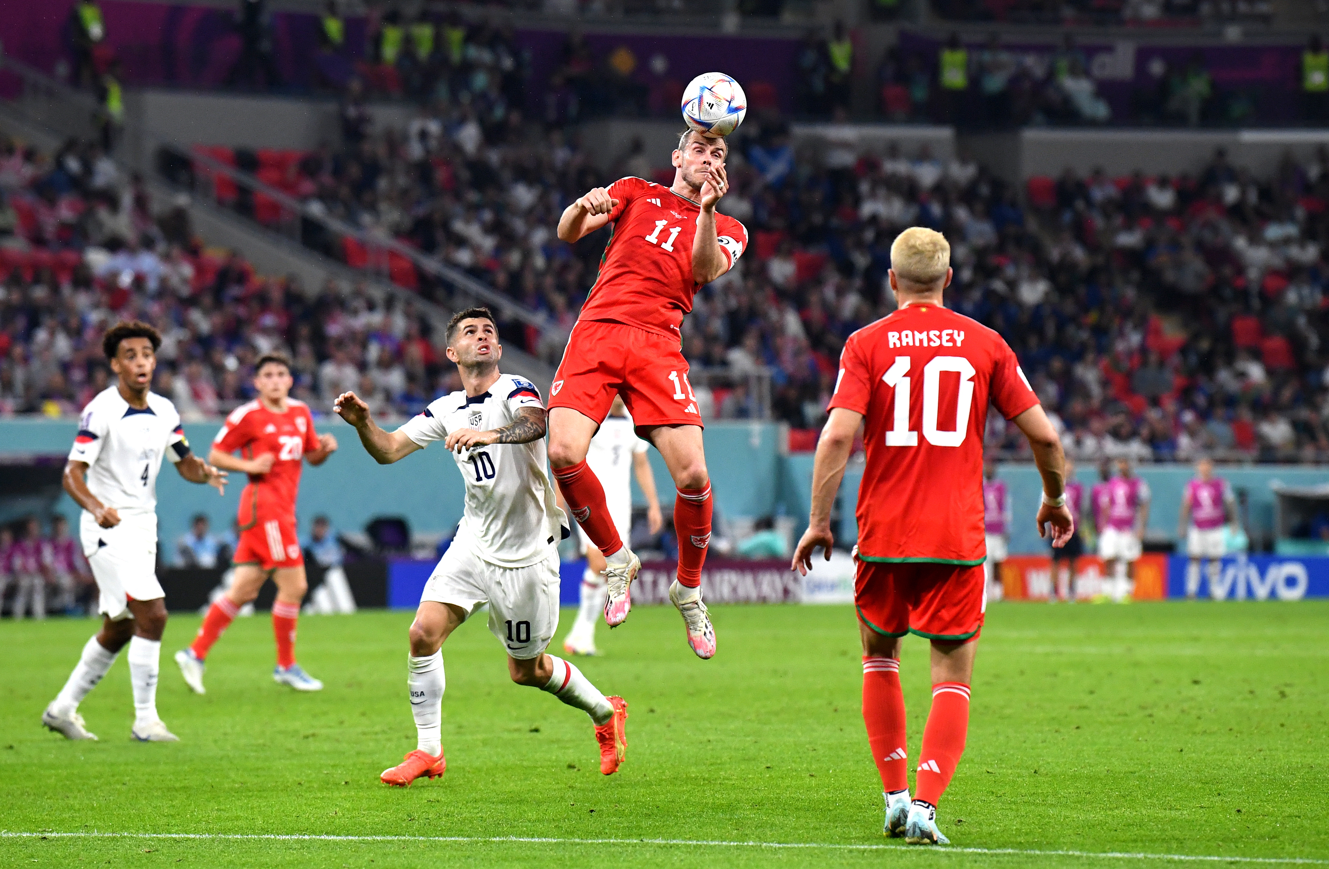 Doha (Qatar), 21/11/2022.- Gareth Bale (C) of Wales heads the ball in front of Christian Pulisic of the USA during the FIFA World Cup 2022 group B soccer match between the USA and Wales at Ahmad bin Ali Stadium in Doha, Qatar, 21 November 2022. (Mundial de Fútbol, Estados Unidos, Catar) EFE/EPA/Neil Hall