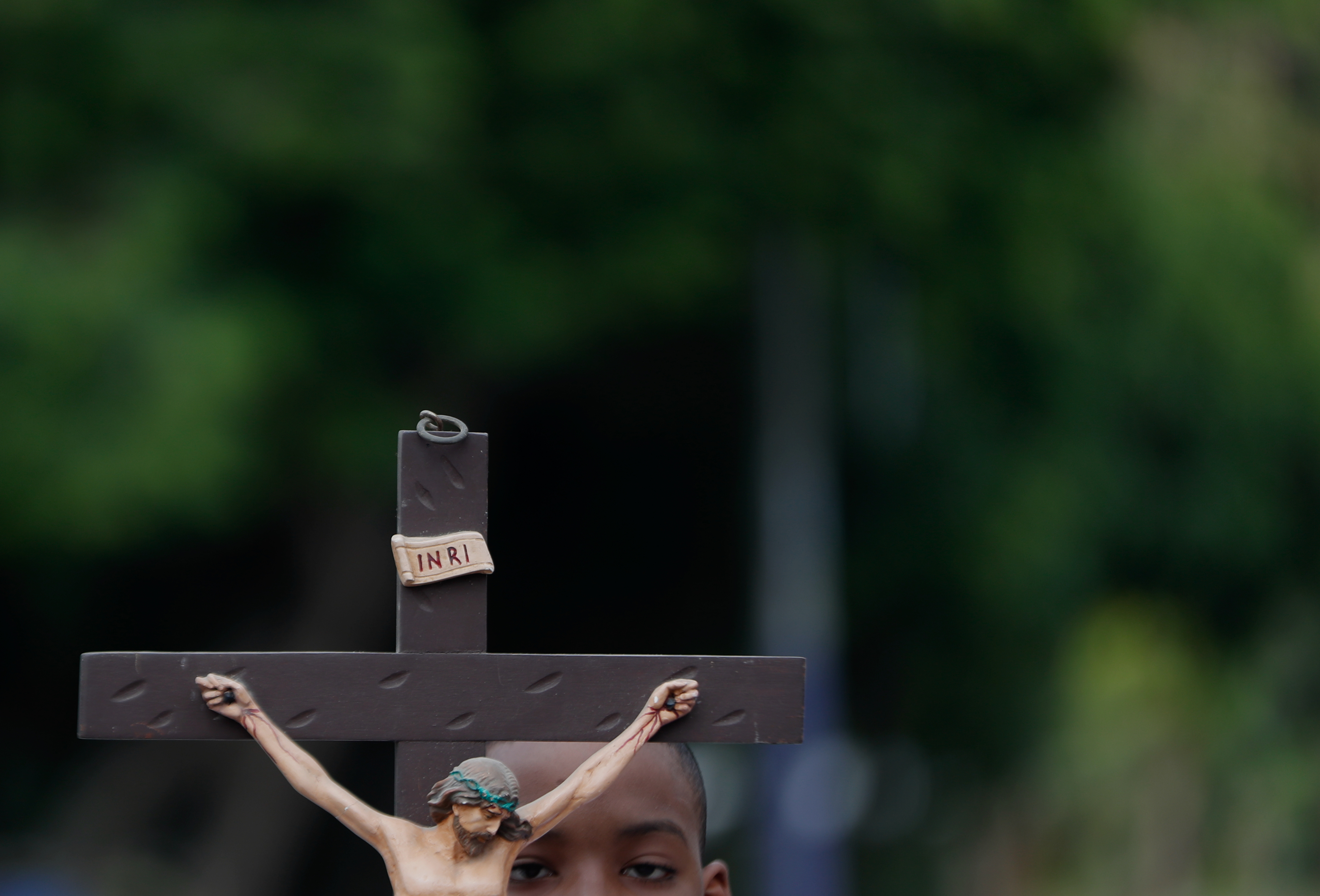 -FOTODELDÍA- AME3528. CALI (COLOMBIA), 29/03/2024.- Un niño sostiene una imagen de Jesucristo crucificado durante la procesión del Santo Viacrucis este Viernes Santo, como parte de las celebraciones de la Semana Santa, en Cali (Colombia). EFE/Ernesto Guzmán