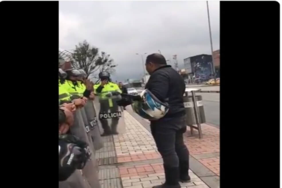Hombre se baja de su moto y ora por policías en medio de la jornada del paro