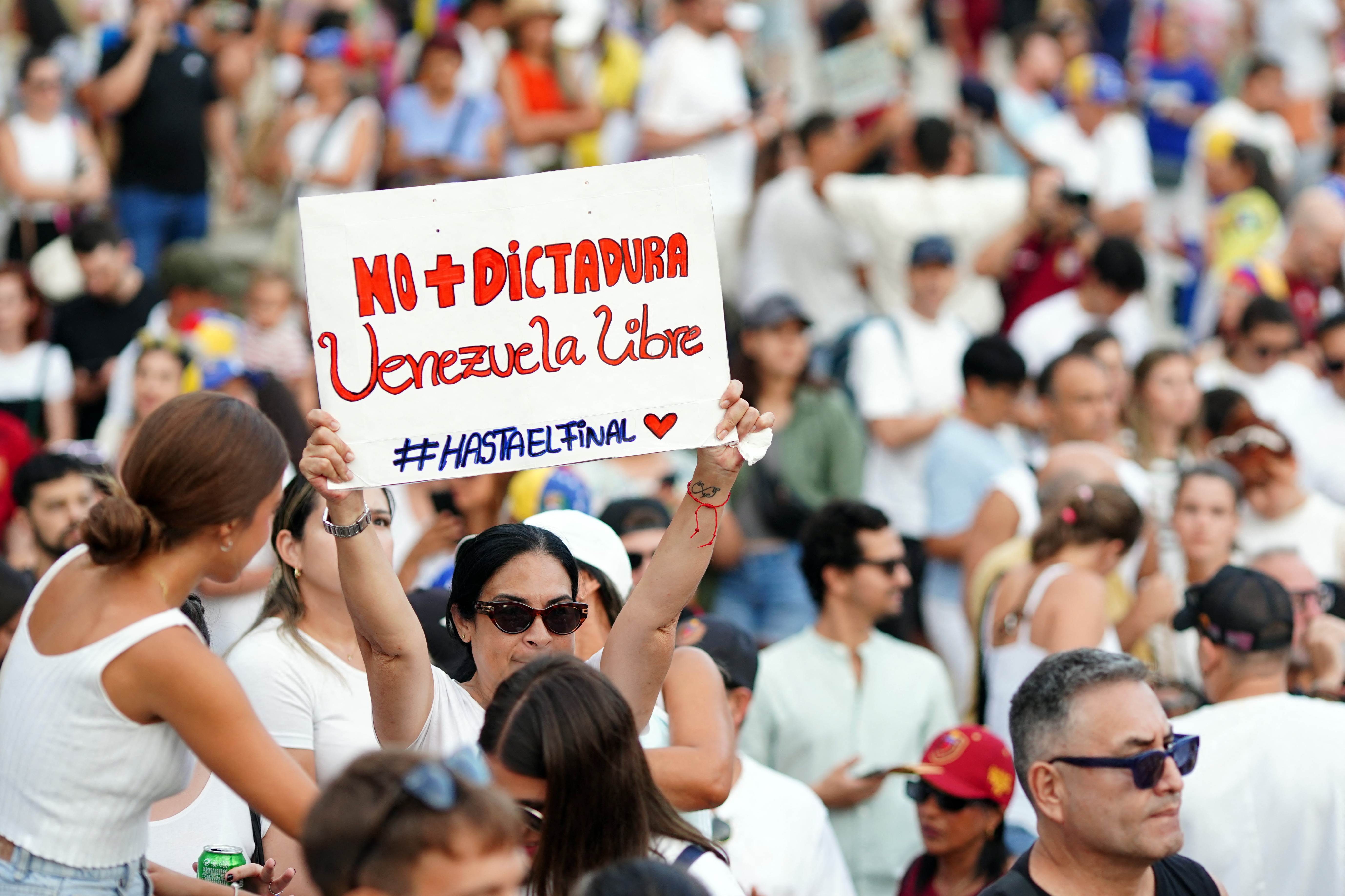 A woman holds a sign reading "No more dictatorship. Free Venezuela" as thousands of people demonstrate after a call for global protests against the results of the disputed election in Venezuela, on August 17, 2024 in Barcelona.