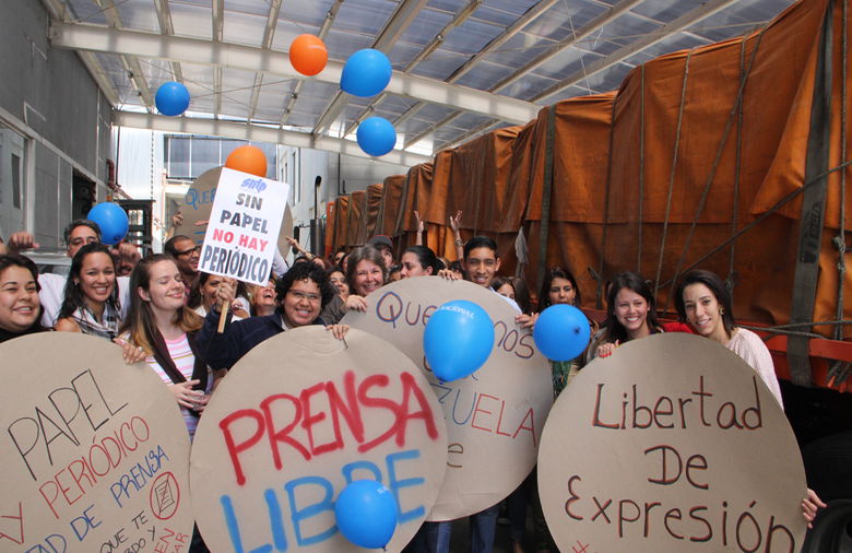 Periodistas y empleados celebran la llegadas de bobinas de papel procedentes de Colombia a las instalaciones del periódico El Nacional.