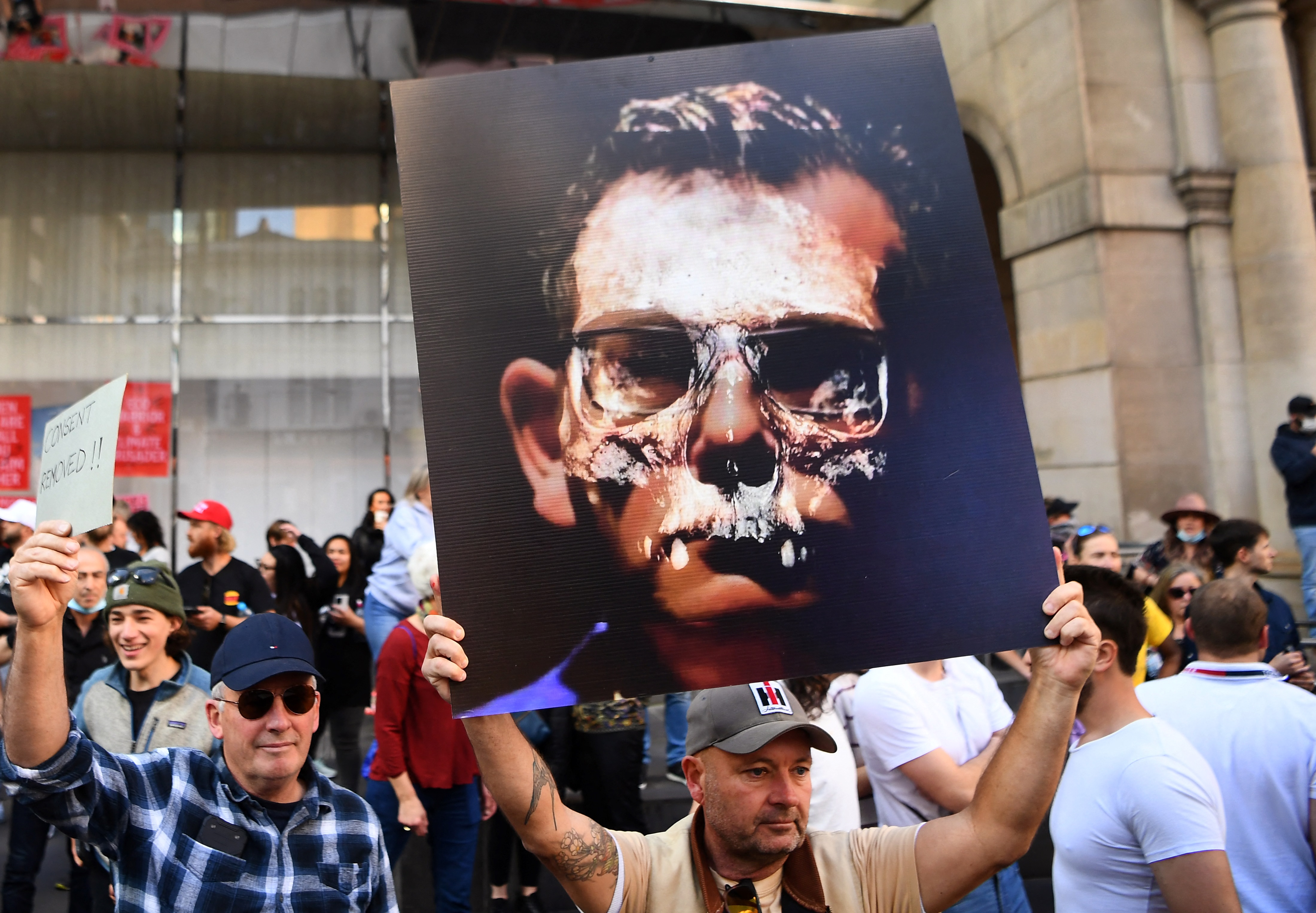 Un manifestante sostiene un cartel con la foto del primer ministro estatal de Victoria, Daniel Andrews, durante una manifestación anti-bloqueo en Melbourne el 21 de agosto de 2021, mientras la ciudad experimenta su sexto bloqueo mientras lucha contra un brote de la variante Delta del coronavirus.