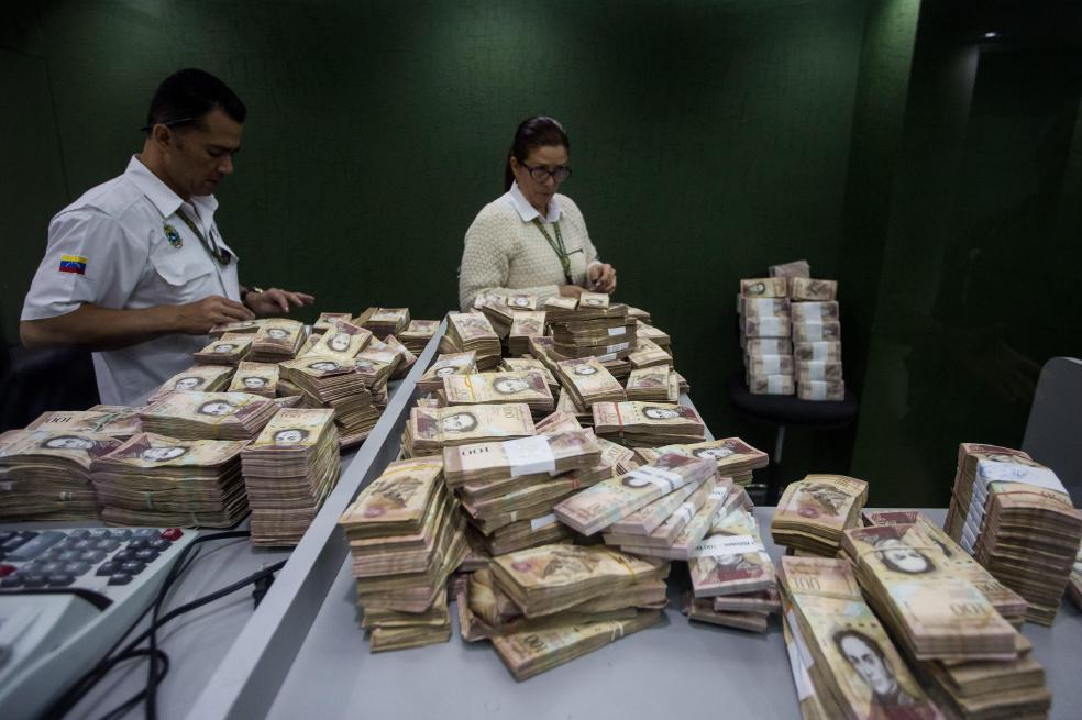 Trabajadores de un banco cuentan billetes de 100 bolívares, que hoy no alcanzan para mucho.  / Efe