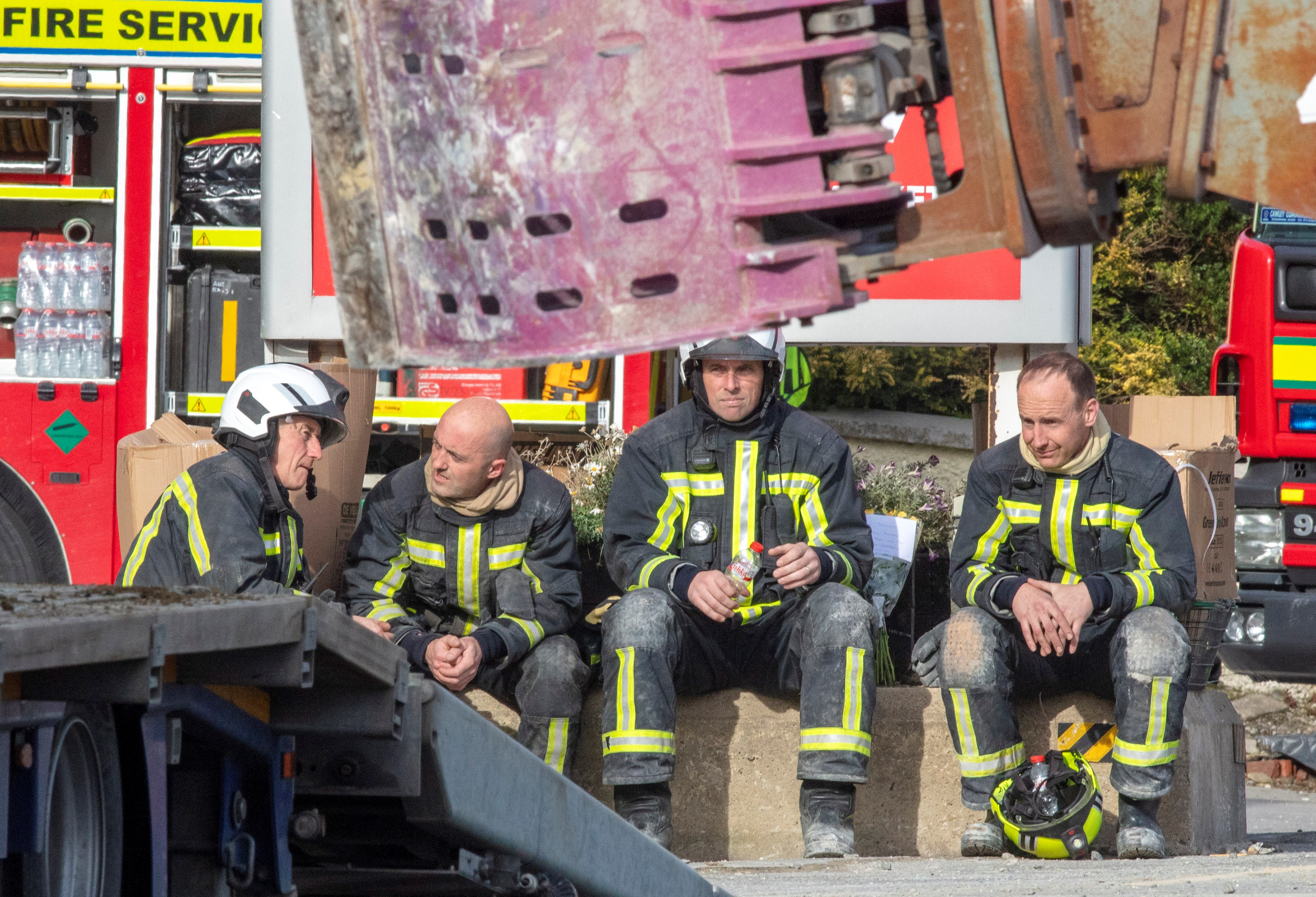 Los miembros de los servicios de emergencia descansan en la escena de una explosión en una gasolinera en Creeslough, en el noroeste de Irlanda el 8 de octubre de 2022.