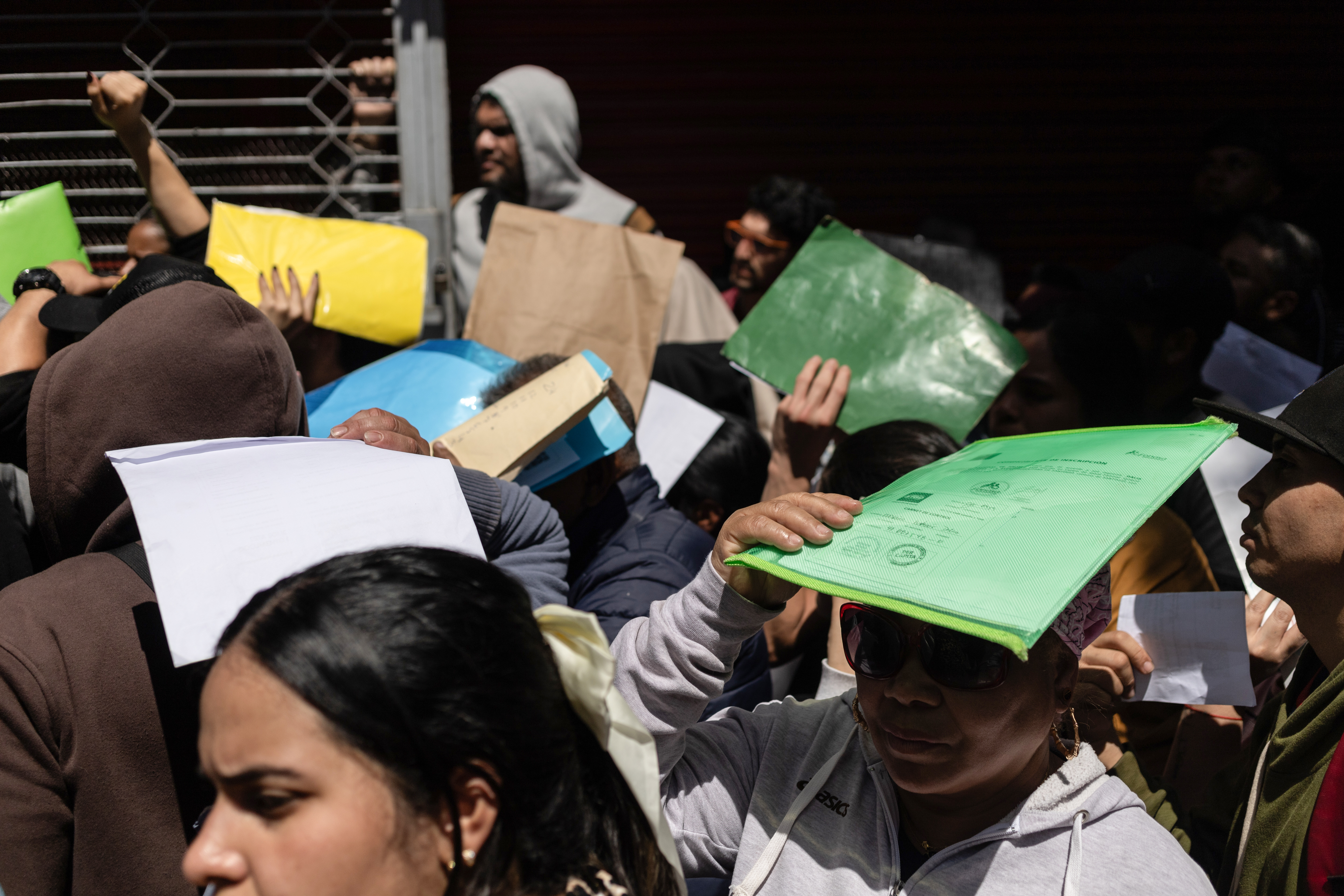 AME5815. SANTIAGO (CHILE), 16/12/2024.- Migrantes se congregan para el proceso de enrolamiento informado por el Registro Civil chileno este lunes, en el estadio Víctor Jara en Santiago (Chile). Miles de migrantes se acumularon en las inmediaciones de Estadio Víctor Jara en Santiago tras un llamado del Registro Civil para enrolarse, pero desde el gobierno advirtieron que una "confusión" entre los asistentes provocó que muchos acudieran a la cita para empadronarse o regularizarse. EFE/ Ailen Díaz