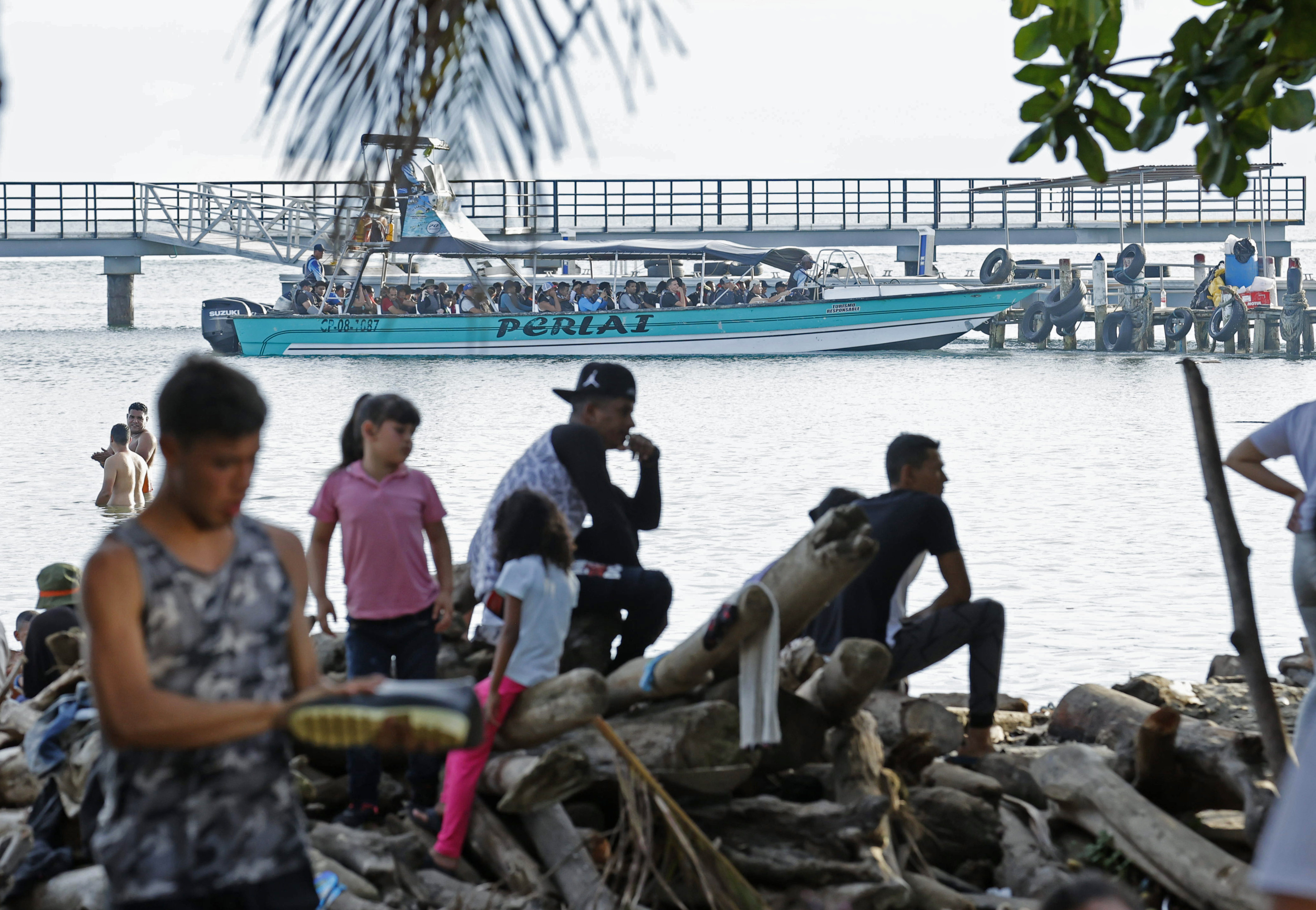 ACOMPAÑA CRÓNICA: COLOMBIA CRISIS MIGRATORIA. AME2685. NECOCLÍ (COLOMBIA), 07/10/2022.- Migrantes esperan para abordar una lancha hacia la frontera con Panamá, el 6 de octubre de 2022, en Necocli (Colombia). En el pueblo colombiano de Necoclí ya se acostumbraron a que a diario cientos de personas acampen en sus playas a la espera de coger las lanchas que los llevan a la frontera de Panamá en una travesía migratoria hacia EE.UU. que crece cada día y amenaza con "explotar". EFE/ Mauricio Dueñas Castañeda