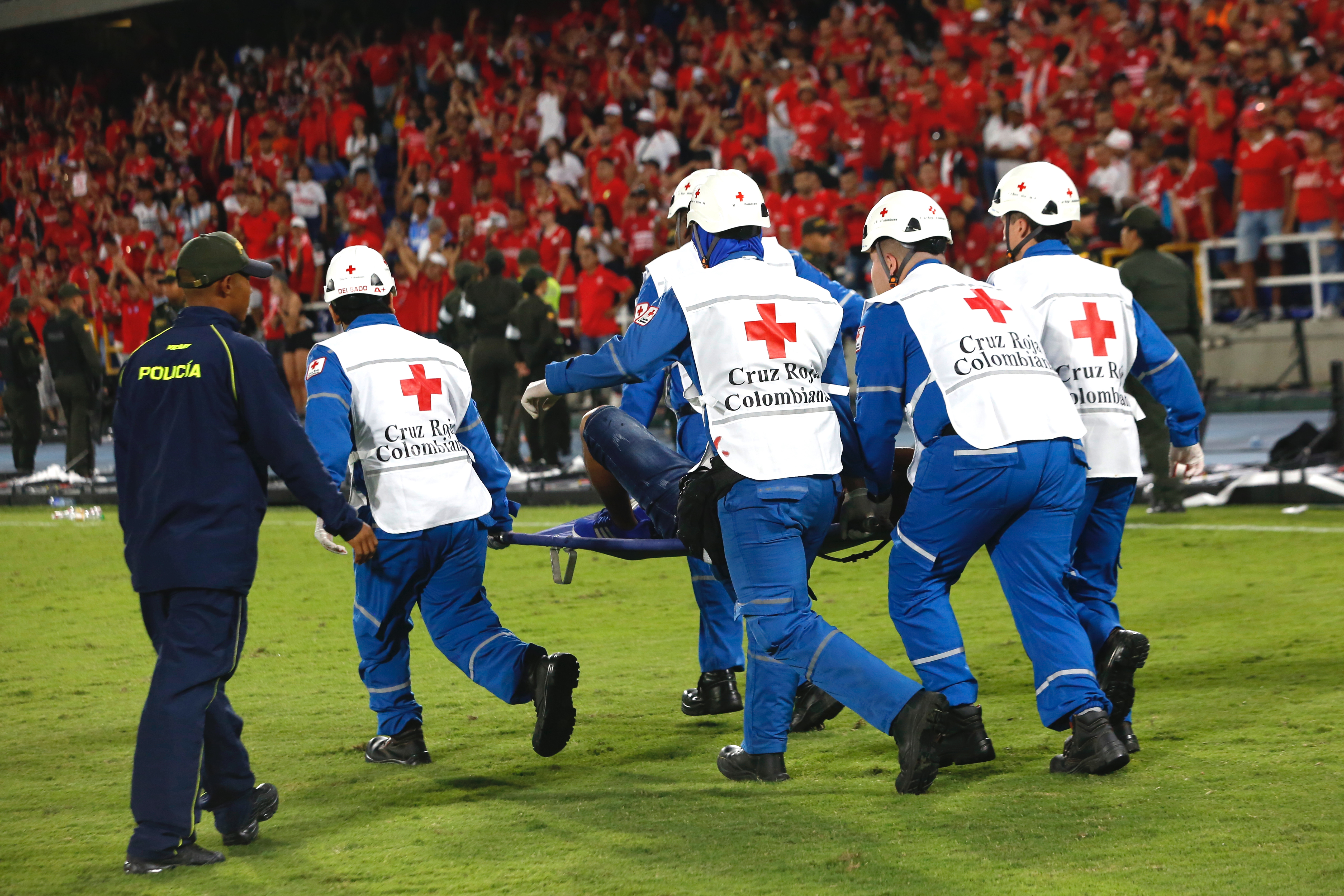 AME5628. CALI (COLOMBIA), 15/12/2024.- Una persona es asistida por integrantes de la Cruz Roja tras unos disturbios en el partido de vuelta de la final de Copa Colombia entre América y Atlético Nacional, este domingo en el Estadio Pascual Guerrero, en Cali (Colombia). EFE/ Ernesto Guzmán