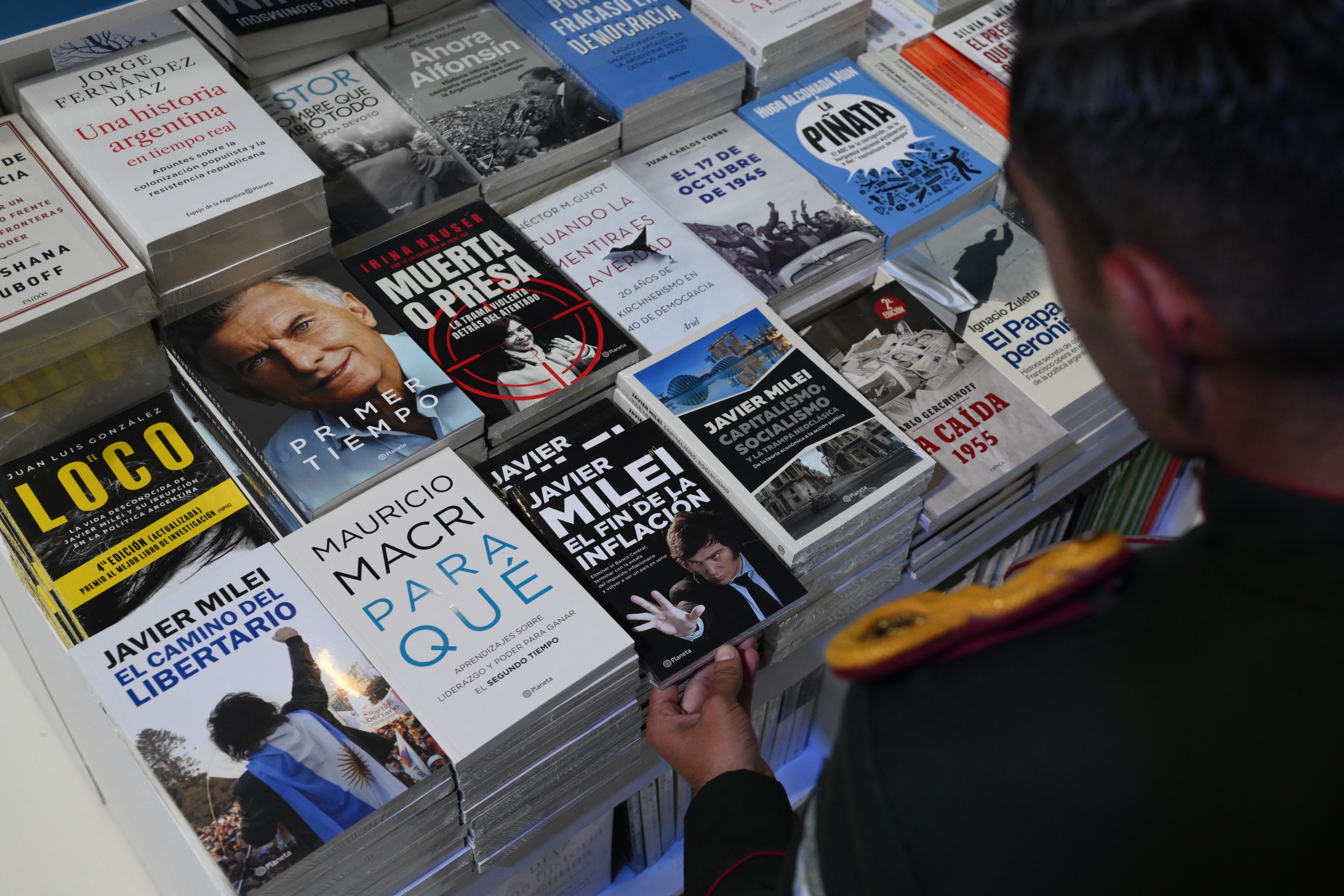 A cadet of the Argentine Gendarmerie grabs a copy of a book by President Javier Milei at the 48th Buenos Aires International Book Fair on April 25, 2024.