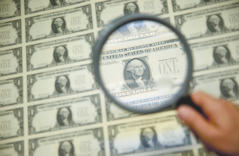 A magnifying glass is held over a 50 subject one dollar note sheet after being printed by an intaglio printing press in this arranged photograph at the U.S. Bureau of Engraving and Printing in Washington, D.C., U.S., on Tuesday, April 14, 2015. Republican efforts to pass a fiscal year 2016 budget cleared another hurdle as the House named its members to a conference committee and Senate Majority Leader Mitch McConnell pledged to do the same by the end of the week. Photographer: Andrew Harrer/Bloomberg