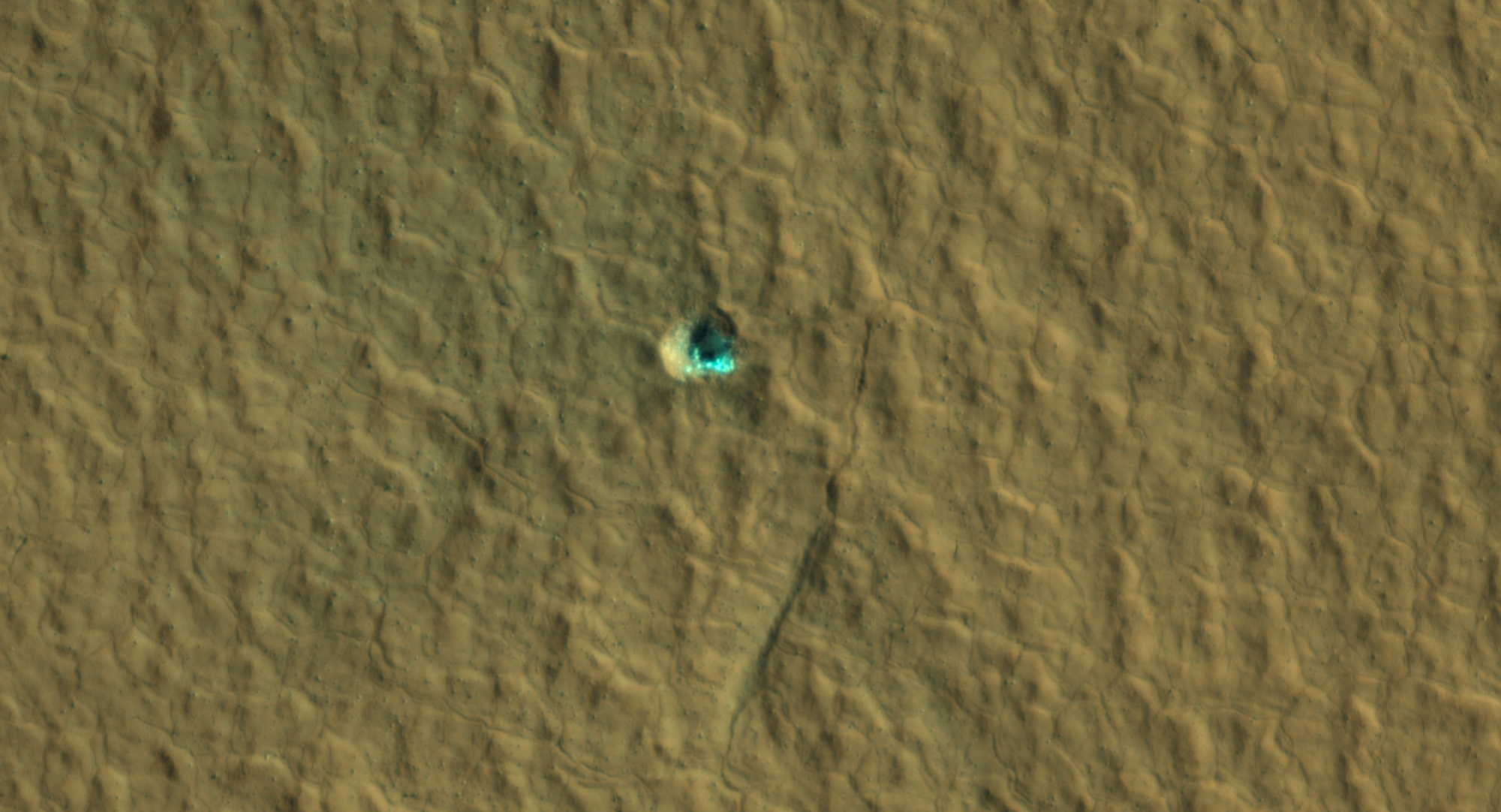 El cráter de impacto que deja al descubierto el hielo en el centro de esta imagen es un ejemplo de lo que buscan los científicos al cartografiar los lugares donde deberían aterrizar los futuros astronautas en Marte. Es uno de los varios impactos de este tipo incorporados a la última versión de una serie de mapas financiados por la NASA del hielo de agua subsuperficial en el Planeta Rojo.