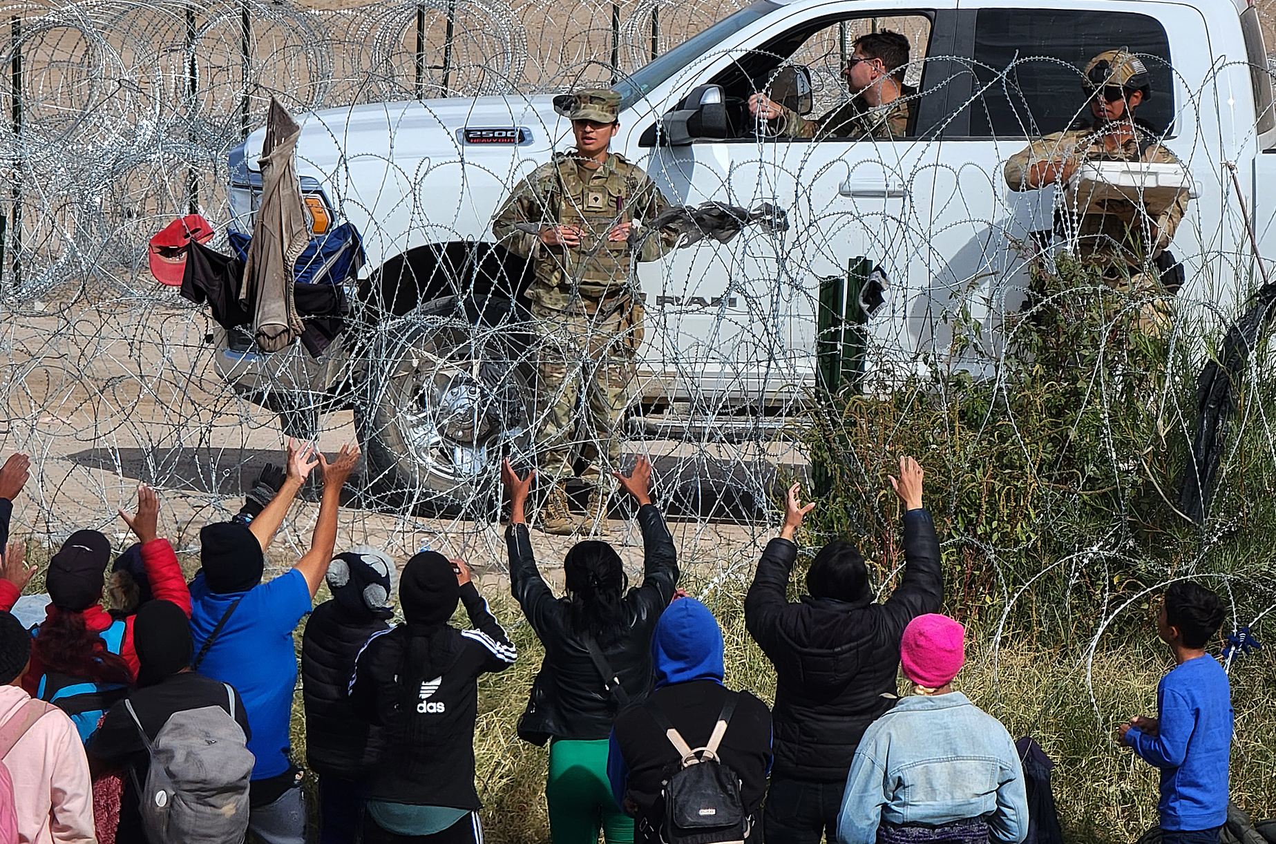 MEX5375. CIUDAD JUÁREZ (MÉXICO), 31/12/2023.- Migrantes se acercan a una concertina que divide a México de los Estados Unidos, el 29 de diciembre de 2023, en Ciudad Juárez, Chihuahua (México). La migración sacudió como nunca a las poblaciones de la frontera norte de México este 2023, en medio de una llegada inédita de migrantes que, además, trastornó el comercio con Estados Unidos. EFE/ Luis Torres