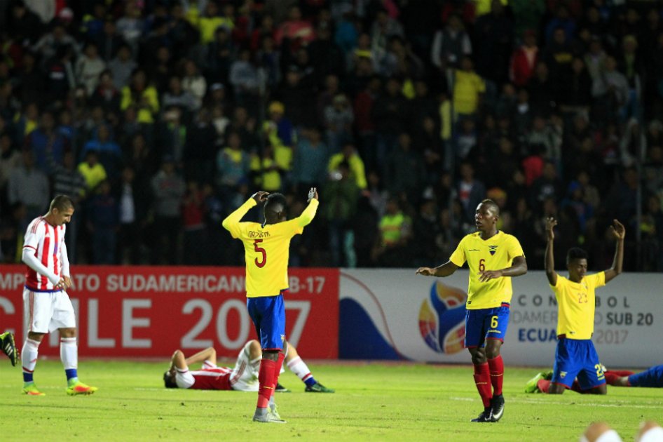 Los futbolistas de Ecuador celebran, mientras se hace presente la tristeza de los paraguayos. / EFE