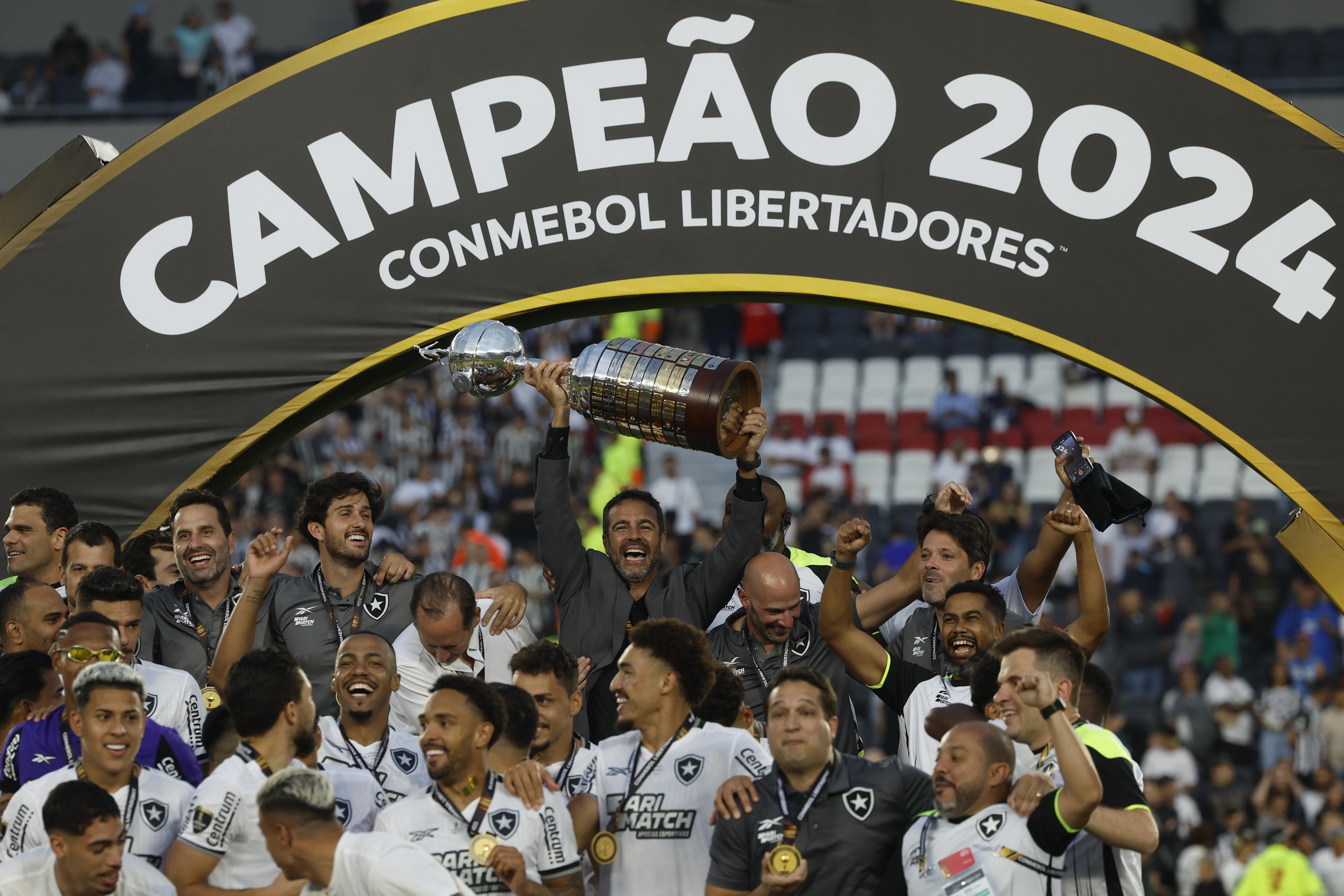 -FOTODELDÍA-EVE6140. BUENOS AIRES (ARGENTINA), 30/11/2024.- El entrenador de Botafogo Artur Jorge (c) celebra con el trofeo al ganar la Copa Libertadores ante Atlético Mineiro este sábado, en el estadio Más Monumental en Buenos Aires (Argentina). EFE/ Antonio Lacerda