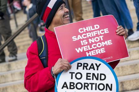 Un señor que participó de "La marcha por la vida" salió a las calles de Washington con dos pancartas que decían "El sacrificio de los niños no es bienvenido aquí" y "Recen para acabar con el aborto".