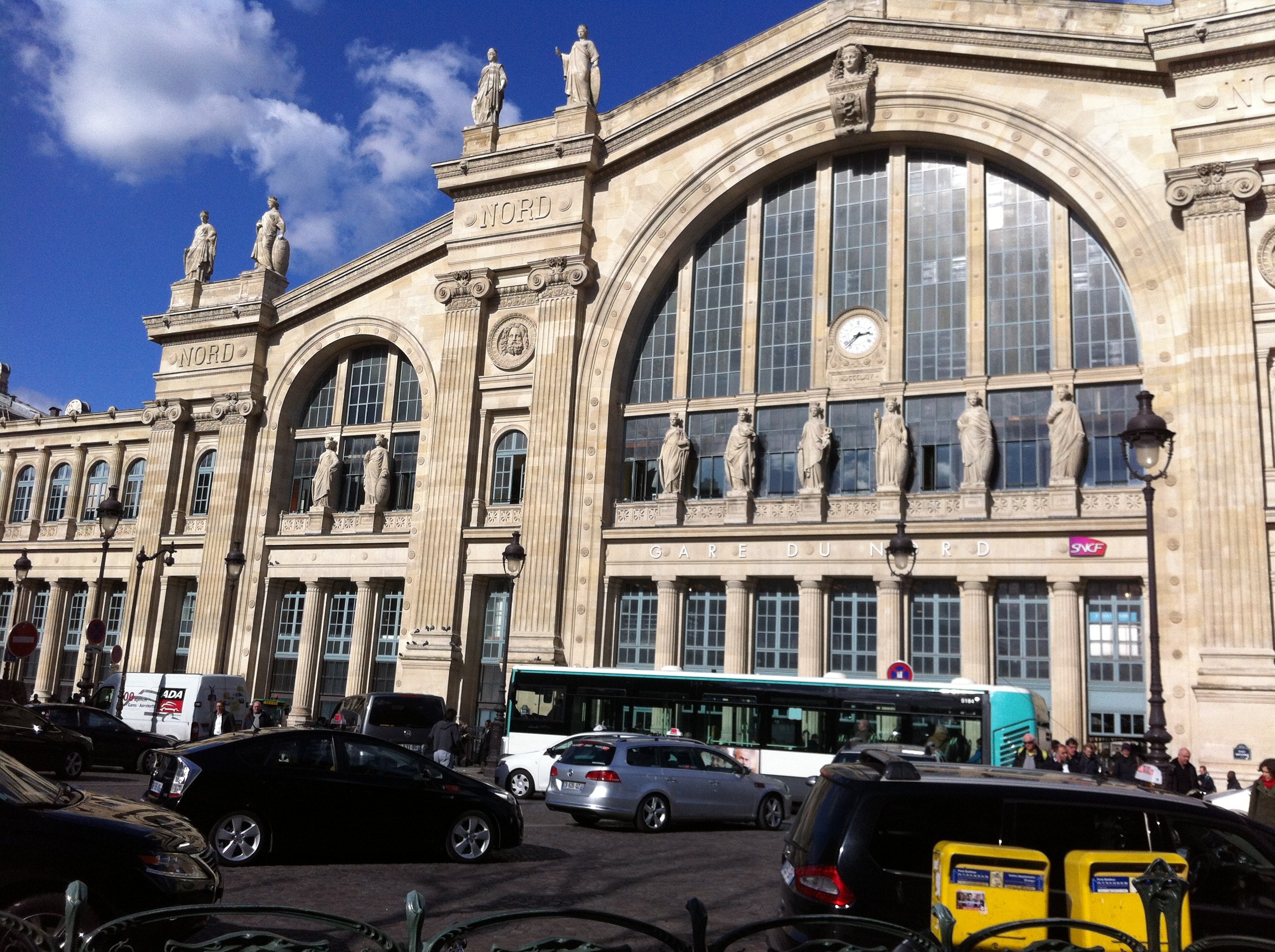 La Gare du Nord es la estación más importante de la capital francesa y una de las más transitadas de Europa, con cientos de millones de pasajeros al año. Inaugurada en el siglo XIX y diseñada por el arquitecto Jacques Ignace Hittorff, destaca por su imponente fachada neoclásica coronada por un gran arco y decorada con 23 estatuas que representan las ciudades conectadas por la red ferroviaria. Desde aquí parten trenes hacia el norte de Francia y destinos internacionales como Londres, Bélgica o Países Bajos, consolidándola como un eje clave