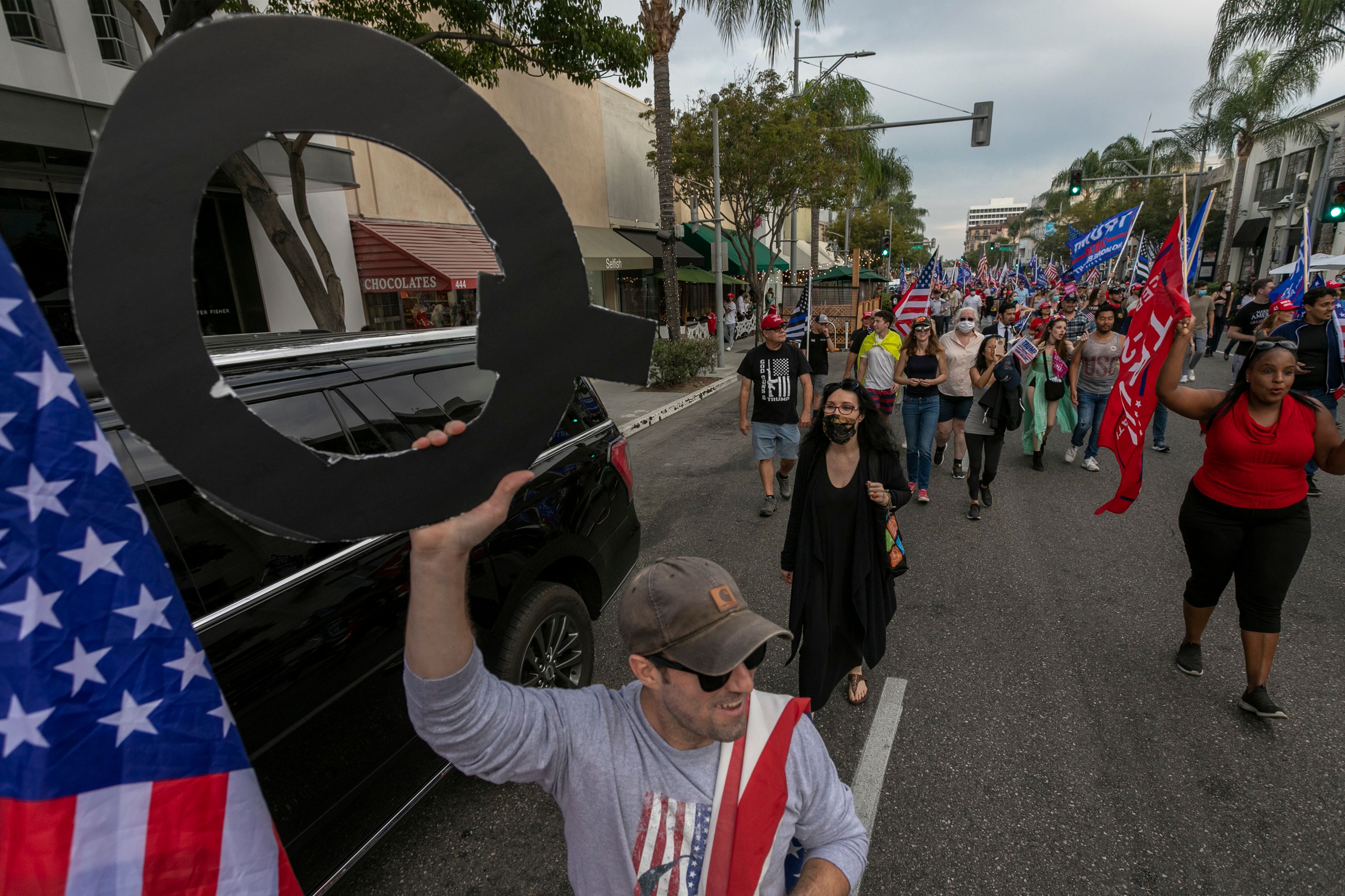 Un hombre sostiene un cartel con la Q de QAnon, el grupo conspiracionista.
