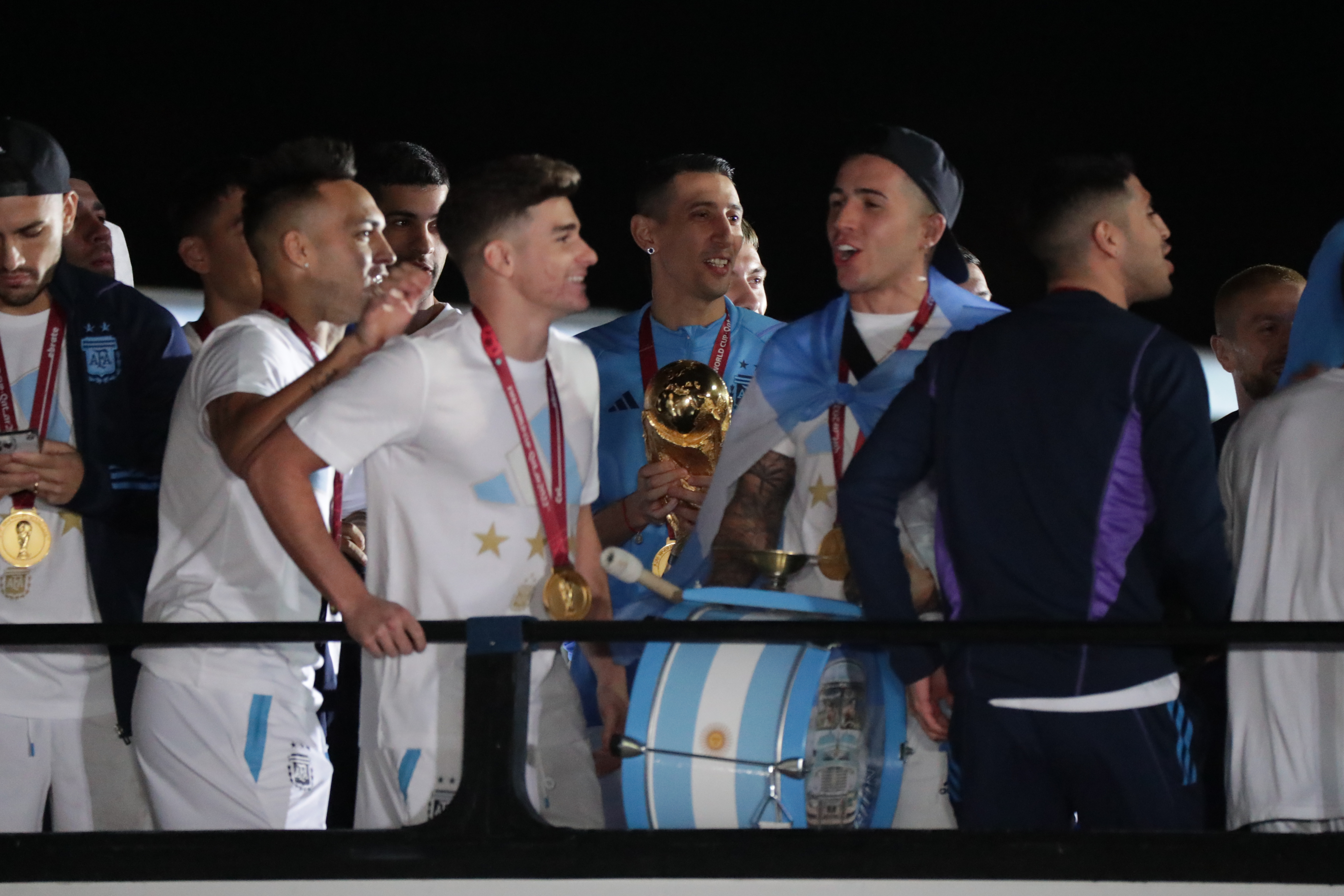 AMDEP9828. EZEIZA (ARGENTINA), 19/12/2022.- Ángel di María (c) de la selección argentina de fútbol sostiene el trofeo del Mundial de Fútbol Qatar 2022 a su llegada hoy, al Aeropuerto Internacional de Ezeiza a unos 22km de Buenos Aires (Argentina). La selección argentina de fútbol, que este domingo se proclamó campeona del mundo en Catar tras vencer en la final a Francia en la tanda de penaltis, ya se encuentra en casa, donde fue recibida por una multitud de aficionados. EFE/ Raúl Martínez