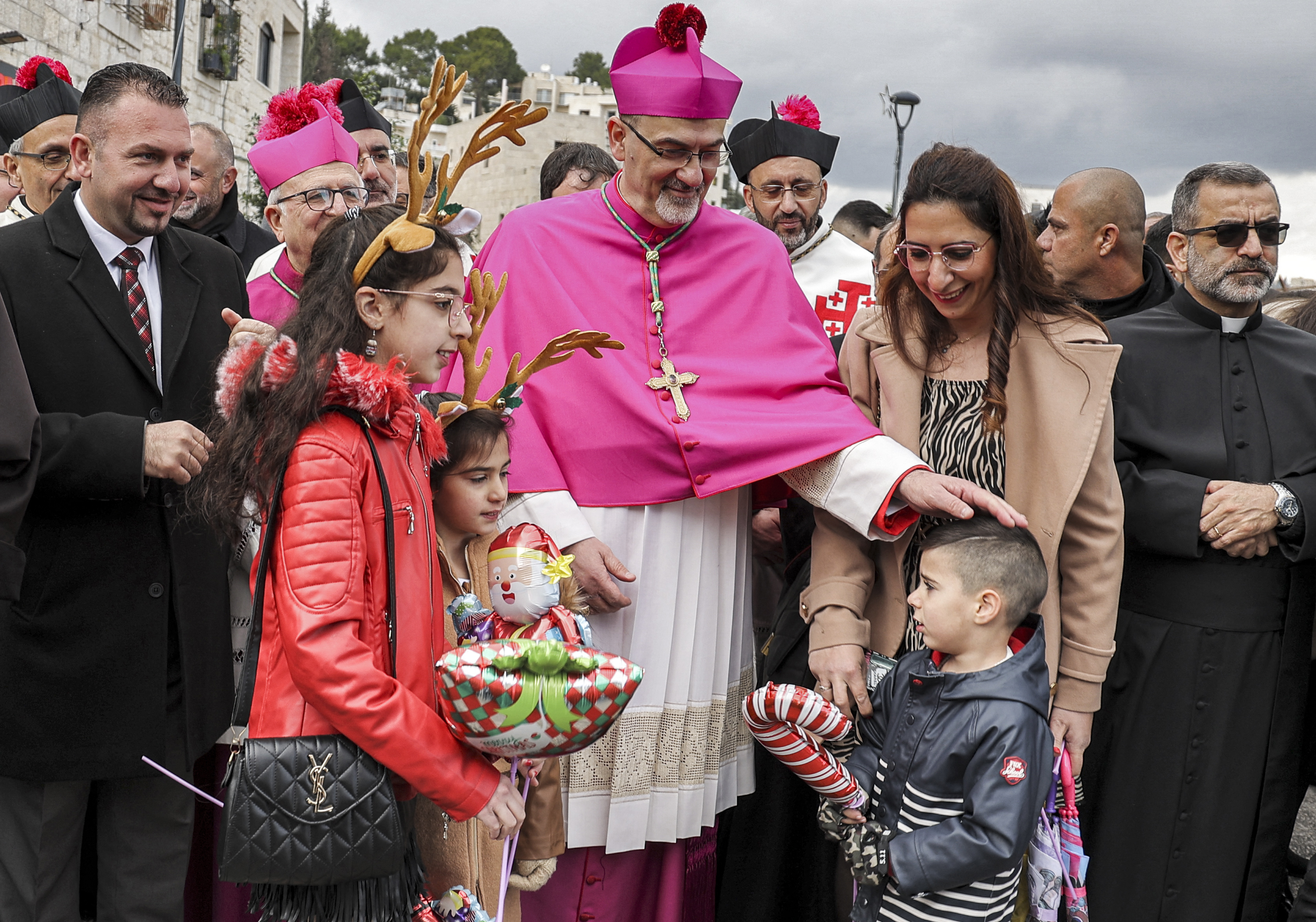 Palestina: Pierbattista Pizzaballa (C), el Patriarca Latino de Jerusalén, saluda a los niños cuando llega a la Iglesia de la Natividad durante las celebraciones navideñas en la ciudad bíblica de Belén en la ocupada Cisjordania en la víspera de Navidad