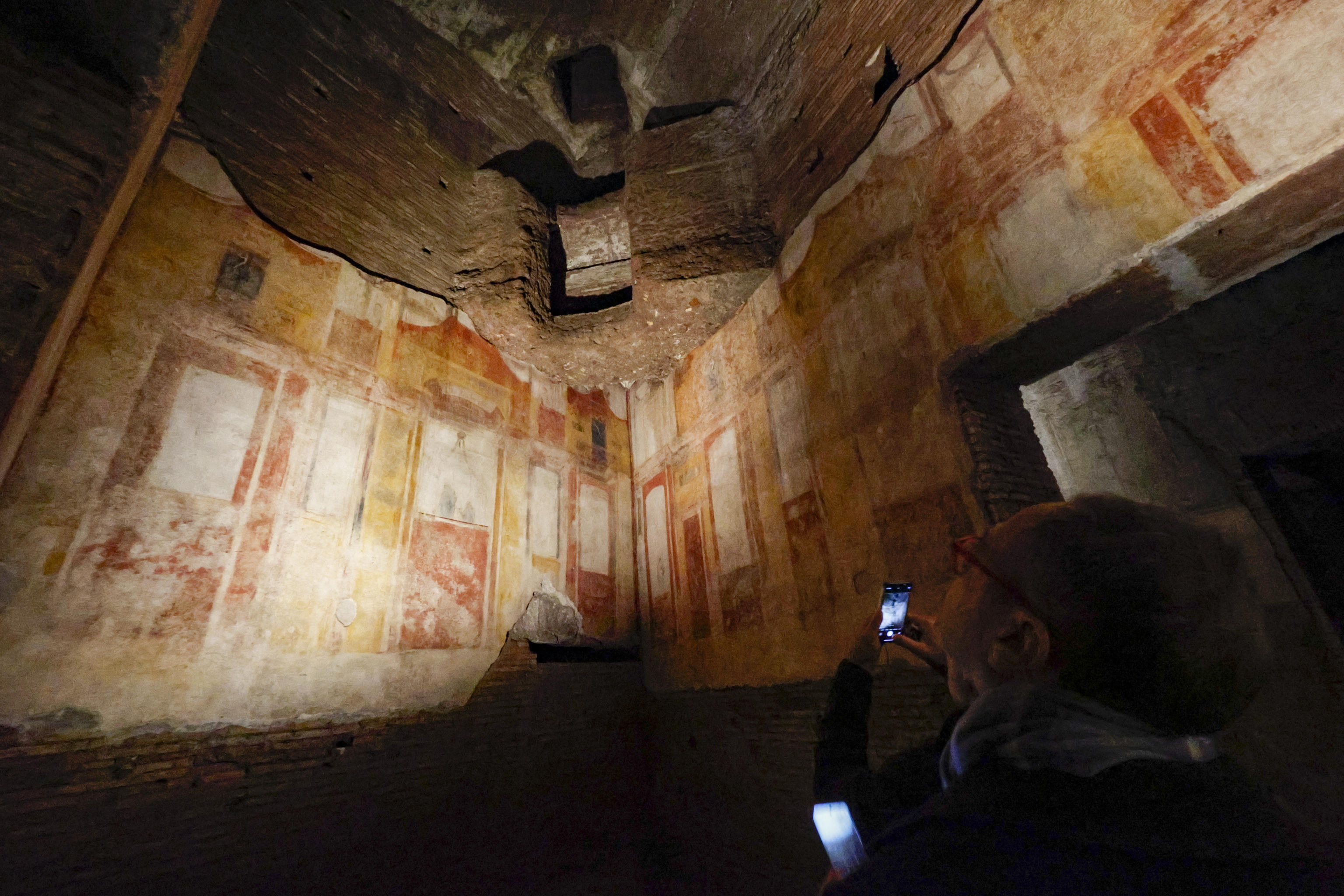 Rome (Italy), 13/12/2024.- People take pictures of an illuminated room with frescos during the presentation of the new entrance and the renovated western side of the Domus Aurea during its inauguration in Rome, Italy, 13 December 2024. A part of the Domus Aurea (Golden House), the vast palace built by Emperor Nero in 64 AD, reopened to the public after restoration. (Italia, Roma) EFE/EPA/FABIO FRUSTACI