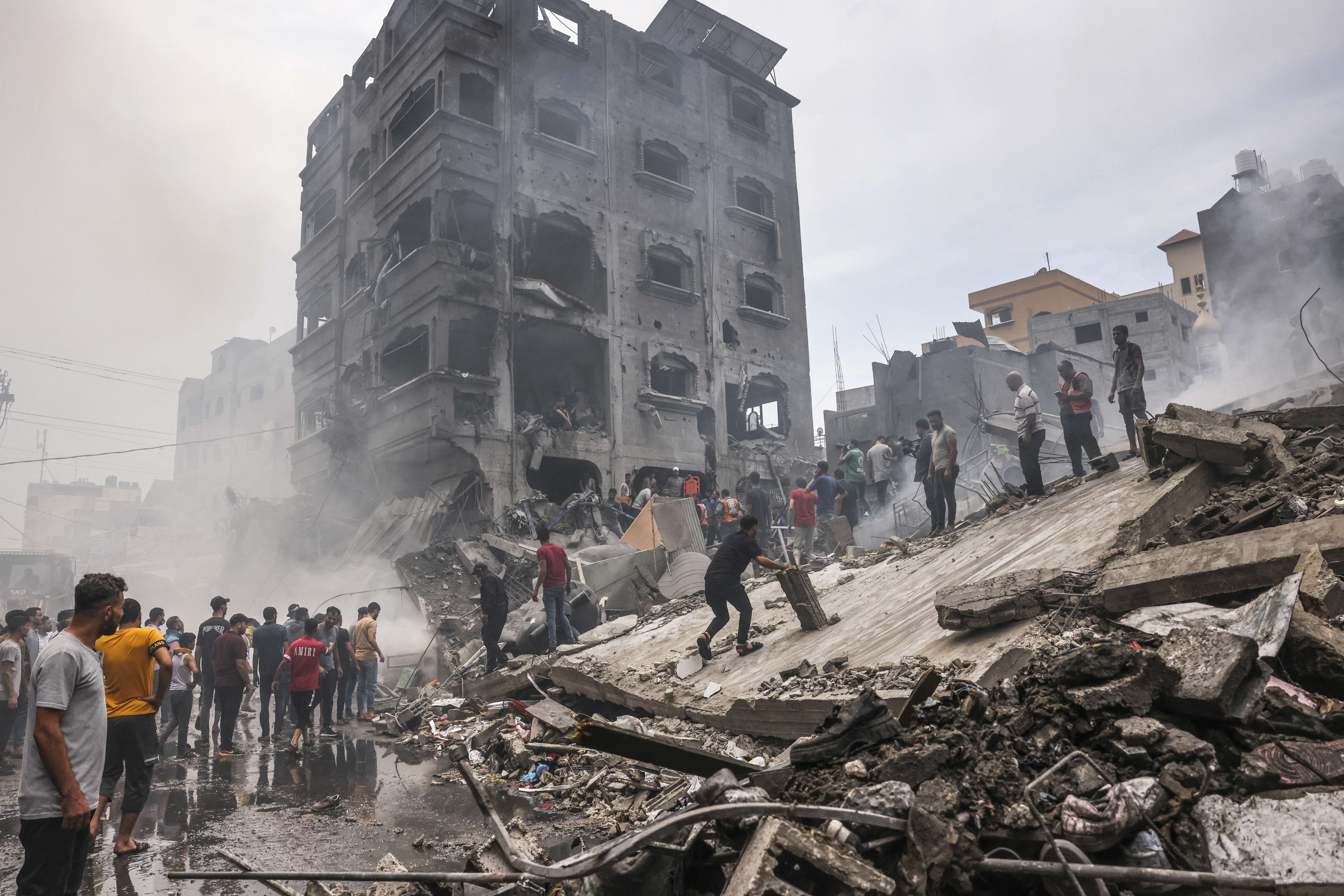 Palestinos buscan supervivientes después de un ataque aéreo israelí contra edificios en el campo de refugiados de Jabalia, en la Franja de Gaza, el 9 de octubre de 2023.