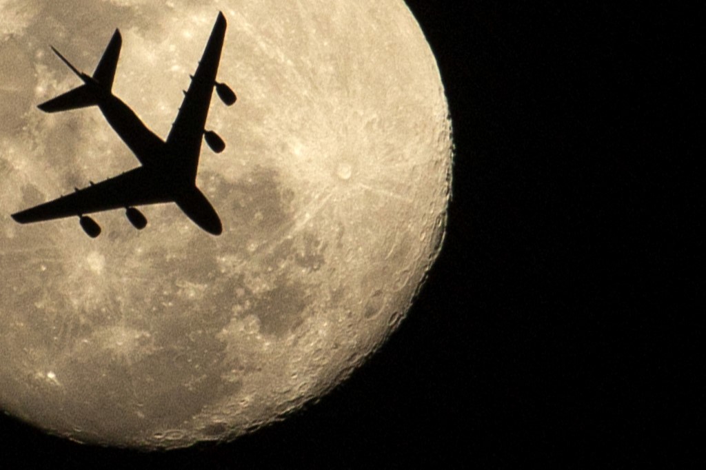 ⠀Un avión es capturado sobre la superluna rosa en la ciudad de Basra, Iraq.