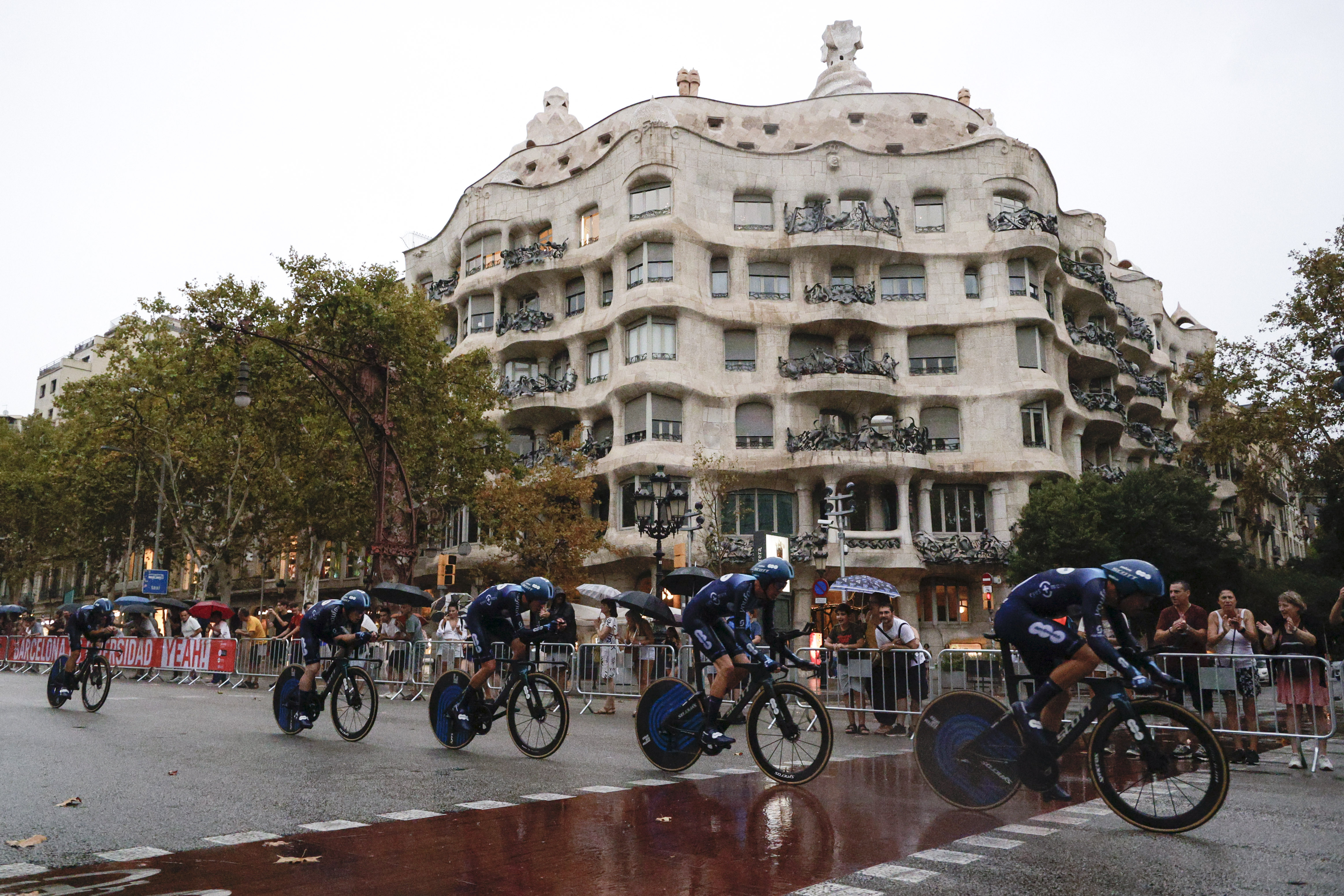 BARCELONA, 26/08/2023.- Los corredores del Team DSM-Firmenich pasan por delante de la Pedrera durante la primera etapa de La Vuelta a España, una contrarreloj por equipos de 14,8 kilómetros que transcurre por las calles de Barcelona. EFE/ Quique García