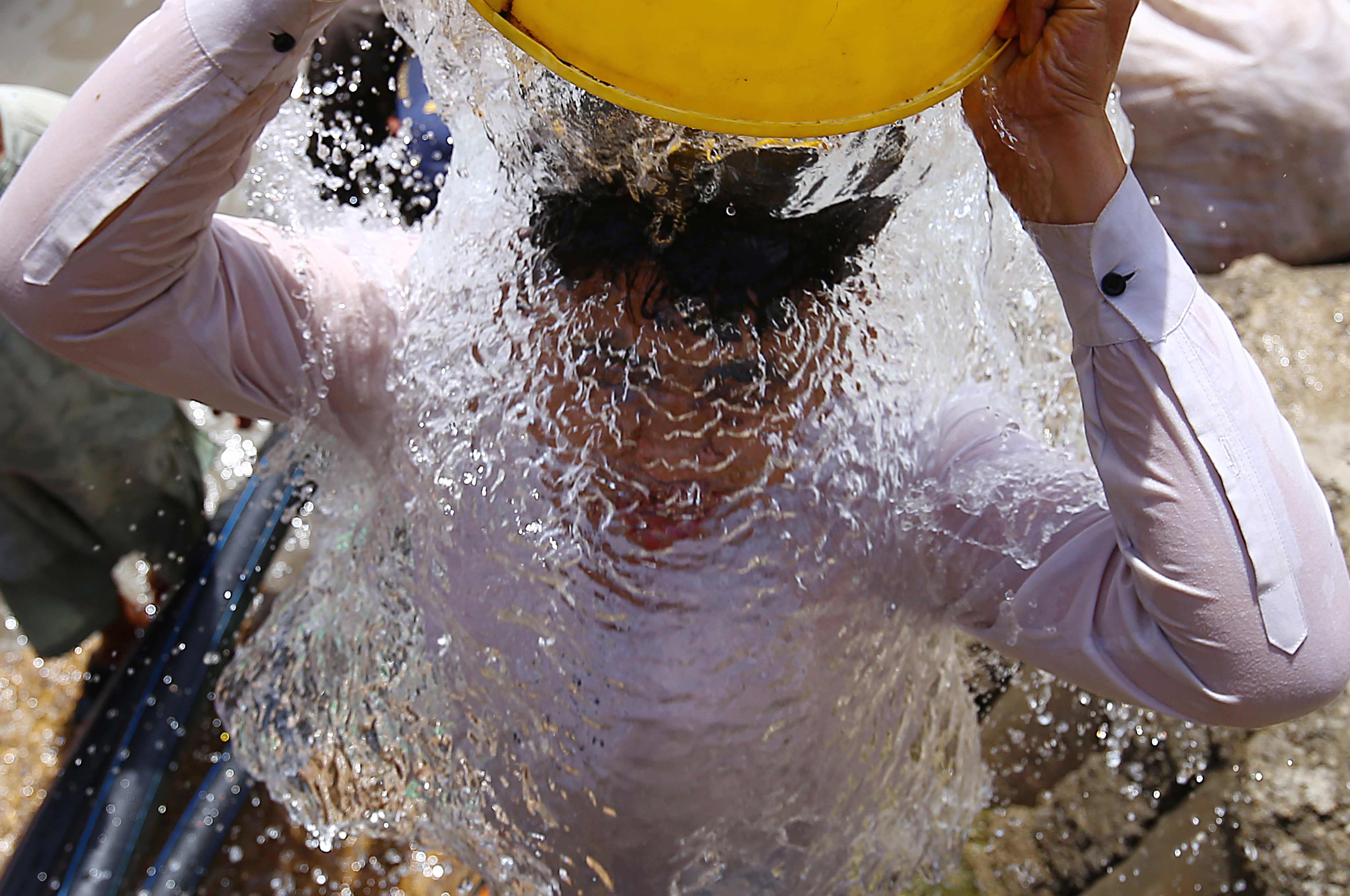-FOTODELDÍA- KARACHI (PAKISTÁN), 22/03/2022.- Un niño paquistaní se echa agua en la cabeza, durante el Día Mundial del Agua en Karachi, Pakistán, el 22 de marzo de 2022. El Día Mundial del Agua se celebra anualmente el 22 de marzo para llamar la atención y aumentar los esfuerzos para el acceso mundial al agua limpia. El tema de este año es Agua subterránea: hacer visible lo invisible. EFE/Shahzaib Akber