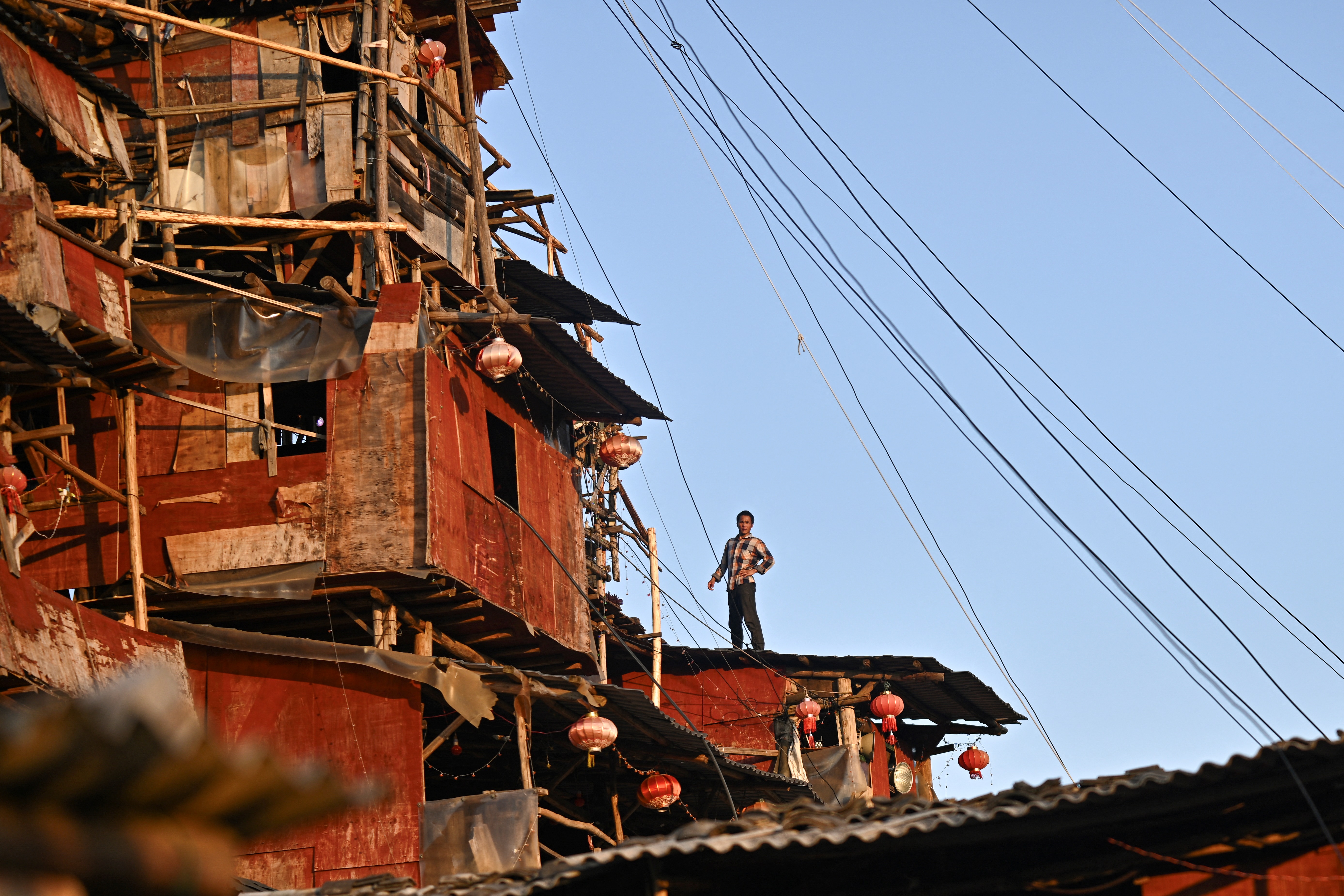 TOPSHOT - This picture taken on May 20, 2025 shows Chen Tianming at his house labelled China's strangest "nail house" -- households that refuse to move in the face of development plans -- in Xingyi, in southwest Guizhou province.