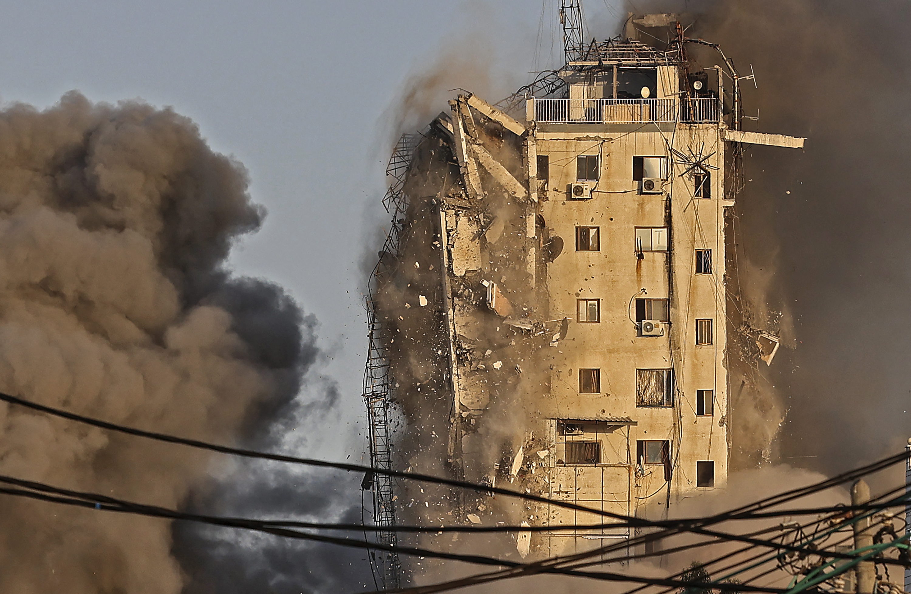 El humo se eleva desde la torre Al-Sharouk mientras se derrumba después de ser golpeada por un ataque aéreo israelí, en la ciudad de Gaza el 12 de mayo de 2021